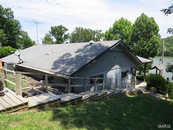 Spacious 2 bed 2 bath lakefront home just a stones throw from Ha Ha Tonka State Park at the beautiful Lake of the Ozarks. This 1232sf home has a extra wide covered porch overlooking the peaceful waters of the 14mm on the Big Niangua arm, allowing for unobstructed views. There are 2 sliding glass doors off of the porch leading into the open concept living room, dining room, & kitchen. Updated appliances in the kitchen, a wood furnace for supplemental heat in the winter, & plenty of room to entertain friends & family. The master bedroom has a walk in closet & a full bath with a skylight & a tiled walk in shower. Outside, there's a nice, gentle slope to the water and mature landscaping. There's also a detached 2 car garage with attic storage and a storage shed with electricity...making this a PERFECT fulltime, vacation, or rental home!