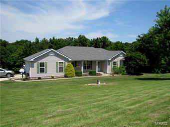 First time on the market, this 1400+ sq ft home on 5.5 acres is now available. Located just outside of city limits, you will have the country setting but won't be too far from town. This atrium ranch features 3 beds, 2 baths with future possibilities of another bed & bath downstairs. Soaring vaulted ceilings greet you when you walk in along with all the natural light from the atrium staircase. Kitchen is oversized galley with a lrg peek through window into the great room. Eating area leads to the large oversized deck overlooking the beautiful acreage and treeline. Master suite has large walk in closet, tray ceilings and full bath with linen closet. Downstairs you won't have to do too much to complete the finish for your future family or rec room.  There is a nice space to finish an office nook, a large 21x14 room that with ceiling and closet is your 4th bedroom.  Bathroom has been started, just a few finishes left to be functional. Side entry 2 car garage. Property is being sold AS-IS.