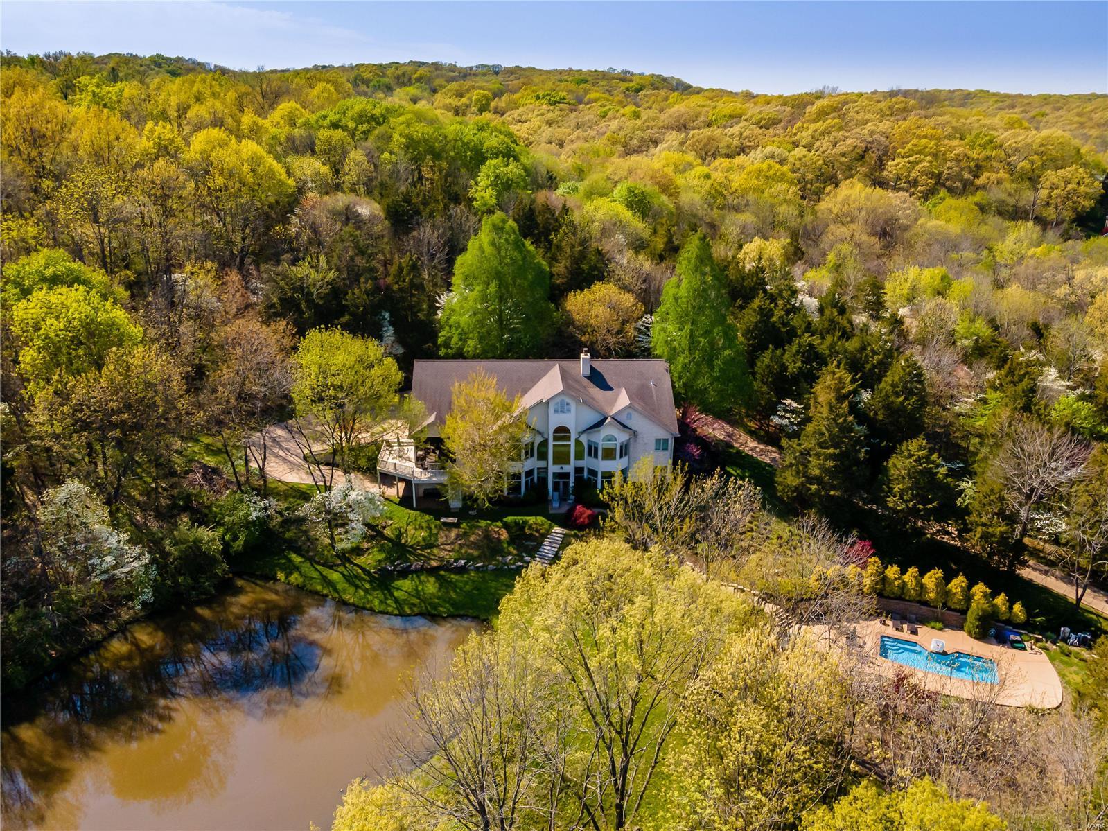 This magnificent atrium ranch on a scenic 7 acre wooded retreat in gated community is waiting for its new owner.  The long tree lined driveway will force you to slow down & take it all in: aesthetically pleasing architecture, low maintenance exterior, private stocked pond, colorful trees & landscaping invites you in. Exquisite finishes & modern comforts interplay w/an unique yet functional floorplan throughout the gracious & inviting spaces. The great rm is worthy of its name w/wall of windows & vaulted ceiling. The dining rm is framed w/ bay window & matching stone wall setting the stage for quality & class. Open Kitchen connects w/the cool screened porch.  Spa like master suite offers spacious master bath & organized walk-in closet. W.O. LL  w/10ft ceiling offers family room w/FF, wine cellar & 2 bdrms, powered by dual geothermal sys. Complete privacy w/ beautiful resorts like setup, heated pool, hot tub, & breathtaking panoramic scenery from every window.  Car Enthusiasts must see! Additional Rooms: Mud Room, Wine Cellar
