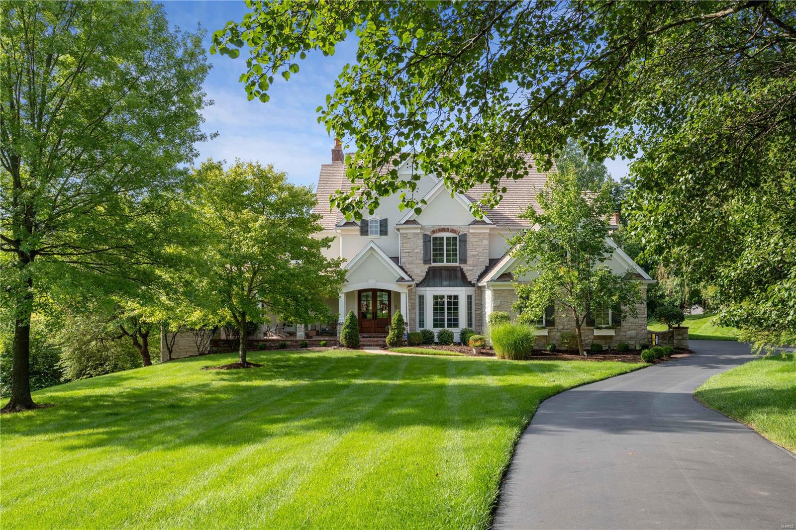 This beautiful stone home holds the distinction of being built on the very first homesite purchased on Morel Ct. The reason being the lot is most spectacular and boasts a fabulous view of the 15th green on Lewis and Clark and offers vast possibilities for a pool to be located on its 1.43 acres. A long front porch has French doors leading from the private Study & its porch swing offers a perfect private elevated locale to enjoy your coffee & view the golf course. The home has a newly remodeled kitchen, new bar, new hardwood flooring on main level & newly remodeled primary bath as well as many upgrades including a 10' foundation which provided opportunity for trey ceilings in the lower level with so many windows it does not feel like a LL. Cedar Closet, Tesla Car charger, custom storage units in the garage, new garage doors and openers, 2 new hot water heaters, new main floor HVAC system, new 2nd floor furnace, new flat screen TV in media room, updated second flr bathrooms. Perfection!