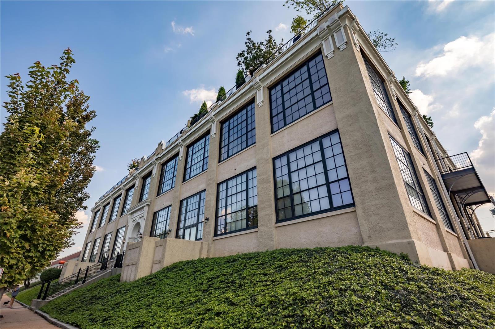 Fantastic 2 plus bedroom/2.5 bath condo with over 2600 sq. ft of light filled space featuring two private outdoor spaces and prime CWE location. The main open concept space includes soaring 18’ ceilings, acres of west facing windows and gleaming hardwood. The oversized kitchen offers tons of cabinetry, marble counters, stainless steel appliances and a center island. A main level master suite includes a luxurious bath with double vanities, walk in shower, and massive walk in closet with custom built ins. Upstairs, a spacious lounge opens to a bedroom space and full bath. A balcony off the dining room and terrace patio are unexpected luxurious extensions of the living space. Main floor laundry and an attached garage with two spaces offer ultimate convenience along with the in building fitness center. Don’t miss the rooftop deck! This unit offers space, character, luxury, a walkable lifestyle and great access to BJC, Cortex, SLU, Washington University and the best of the Central West End. Location: End Unit