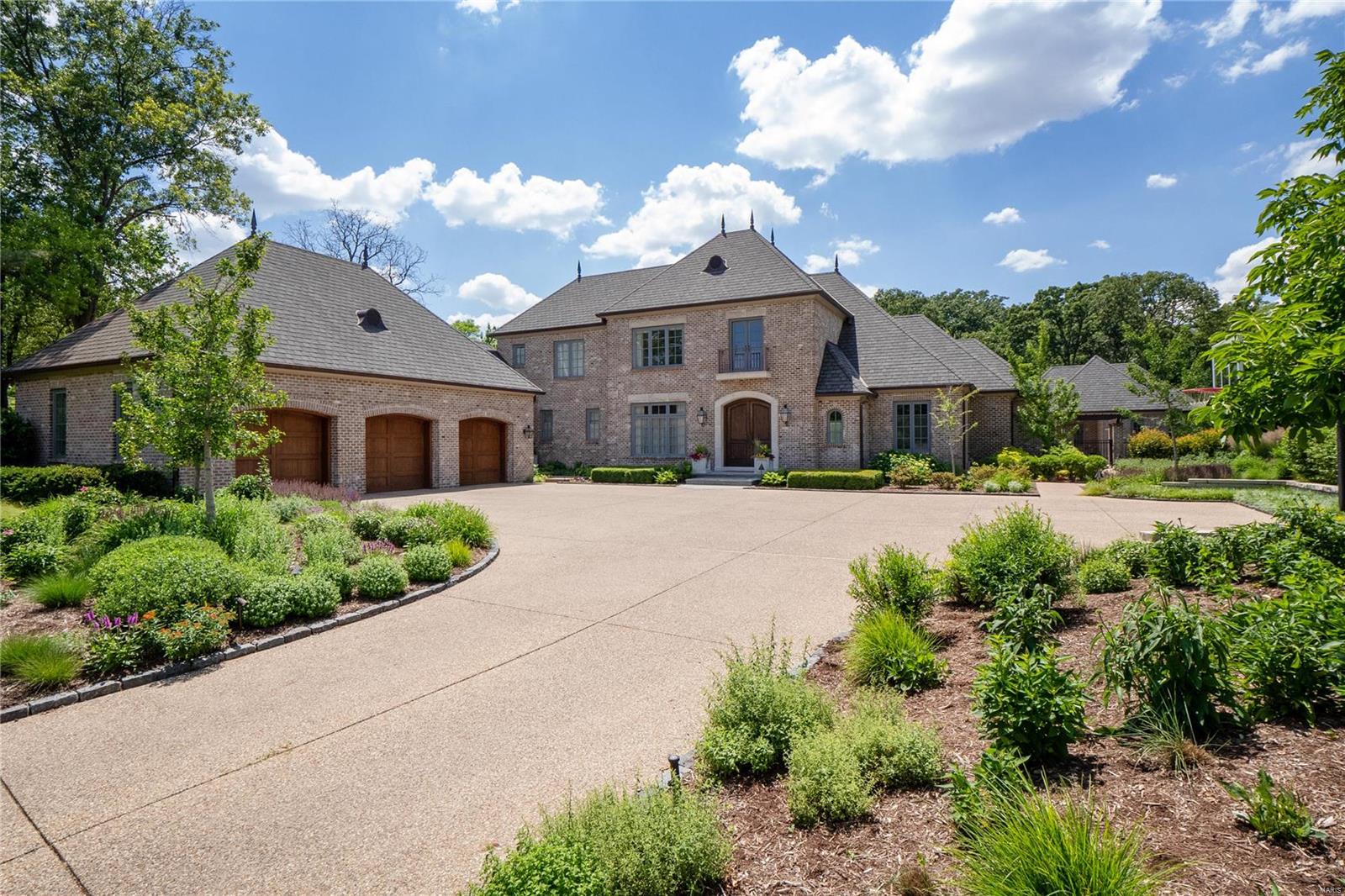 This magnificent 1.5-sty Estate home from award-winning builder Slavin Homes redefines luxury living. Impressive foyer highlighted by dramatic floating staircase leads to private study with custom built-ins, beautifully appointed dining room & stunning family room with limestone fireplace & 3 sets of French doors that open to patio. State-of-the-art kitchen featuring 42” white cabinetry, Carrara marble countertops, commercial grade appliances & butler’s pantry adjoins light-filled breakfast room & vaulted hearth room with floor-to-ceiling stone fireplace.  Coffered master bedroom suite with marble bath with shower spa offers an appealing retreat. The 2nd floor extends the living quarters with 3 ensuite bedrooms, bonus room & 2nd laundry. Lower Level entertainment space includes recreation room with wet bar, game room, media room, office, workout room, 5th bedroom & full bath. French doors open to outdoor living room with brick fireplace, patio, pool house & resort style pool with spa.
