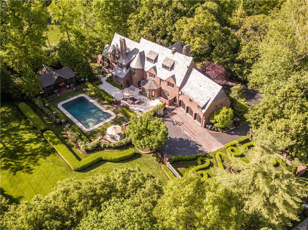 Fall in love with this enchanting storybook English Estate nestled in the heart of Ladue! An Allee of trees beckons you up the circular drive to the front entrance. The main floor delights the senses with a breathtaking foyer from which you can enjoy the Baronial living room, oak-paneled library, conservatory/office in the right wing, or the formal dining room, Chef's kitchen, breakfast room and mud room in the left wing. The grand circular staircase leads to six beautifully appointed bedrooms and baths, including the vaulted ceiling Master Bedroom, Spa Bath with his and her showers and designer dressing room. A third floor great room includes movie, workout, billiard and play areas. An airy pool house with entertainment area overlooks the Pebble-tech swimming pool. Extensive manicured grounds feature a woodland garden with mediation path, boxwood garden with European fountain, sweeping soccer-park lawn with play area. Close to shopping, parks and stroll to brunch or dinner in Clayton! Additional Rooms: Mud Room