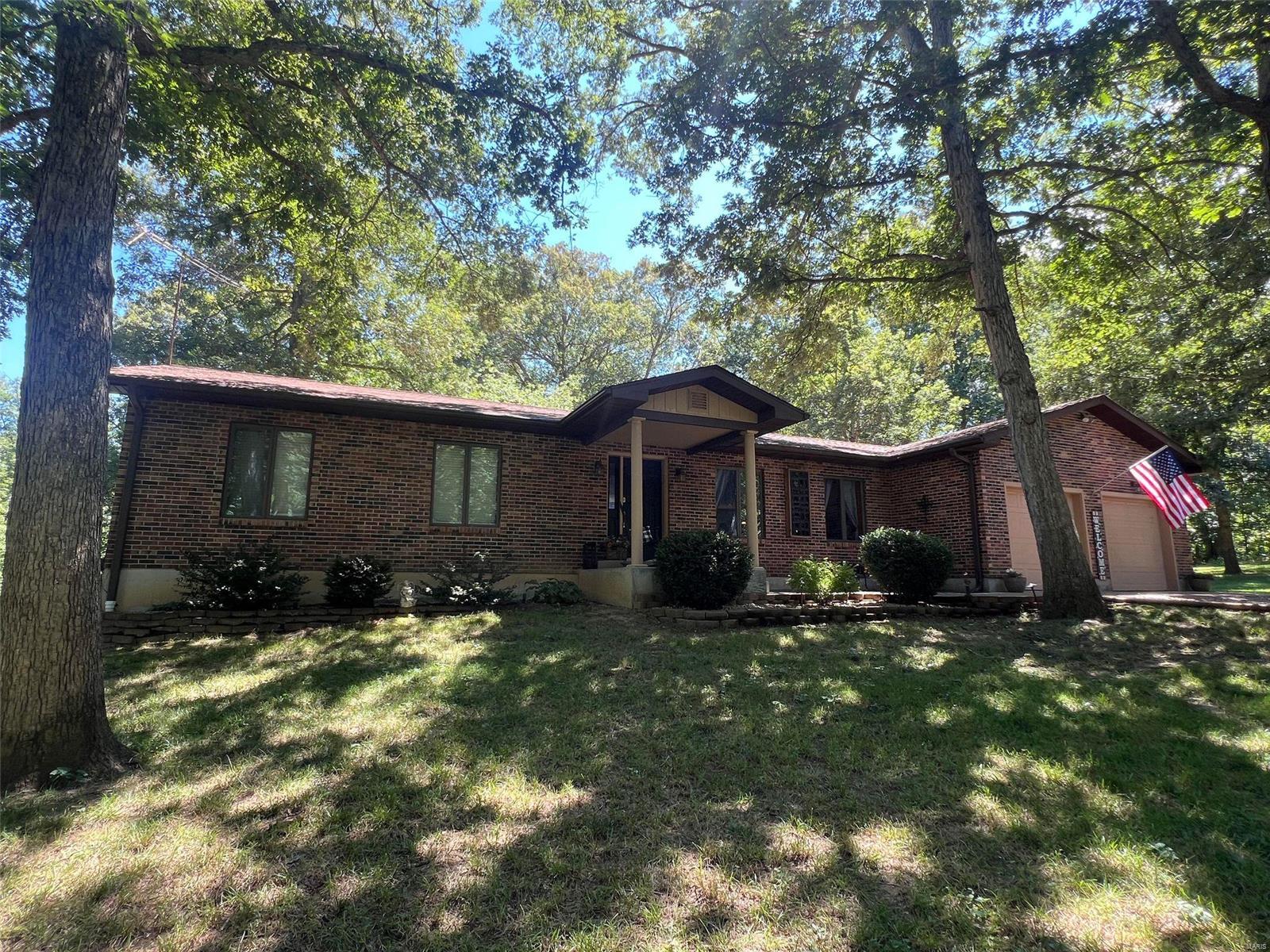 This stunning, well-maintained, brick home sits on its own private park like oasis on 3.2+/- acres of beautiful low-maintenance landscaping and a shared lake. It features 3 bedrooms, 2 bathrooms, and a laundry room all on the main floor, with additional bed/bath in basement. The spacious, open living area and deck off the dining area are ideal for entertaining. Recent updates include a new furnace and air conditioning system (2023), a 3-year-old roof, and newer appliances. The walkout basement offers a large family/entertainment room, an additional bedroom and bathroom, a bonus room, den, and a workbench/storage area. If you love the outdoors, this is your dream home! Enjoy the gorgeous lake from your own dock and relax in the serene surroundings. You'll also find 2 outbuildings and a brick patio fire pit area. Don’t miss out on this piece of paradise!