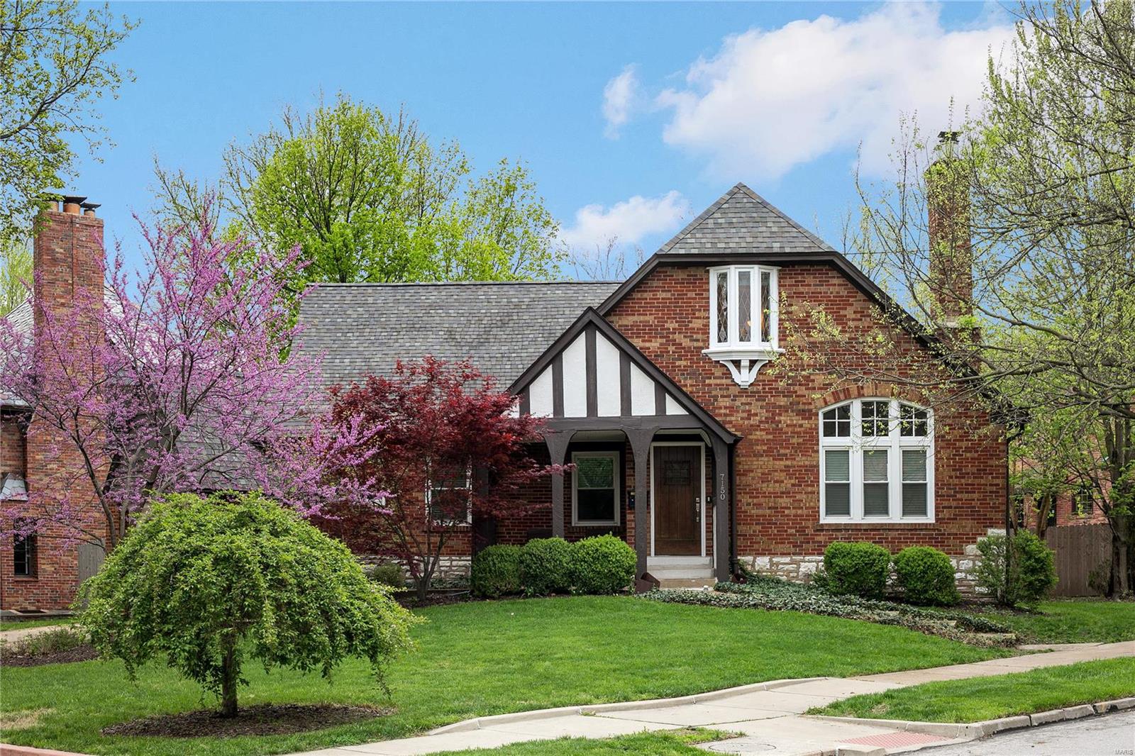 Imagine just moving into this impeccably maintained & updated tudor-style home within walking distance to Winslow's Home & the famed, International Loop. This gracious home greets you w/ a spacious entry foyer & an elegant staircase that leads to the 2nd floor.  Grand formal living room w/ a barrel vaulted ceiling, handsome gas fireplace, exquisite moldings & built-ins.  Hardwood floors throughout.  Formal/Informal dining room is open to the kitchen, ideal for large gatherings for your casual lifestyle.  Updated kitchen w/ granite countertops, stainless appliances & 42" custom cabinets.  1ST FLOOR MASTERSUITE is spacious & light filled + a bonus room off the master which is ideal for a home office/study. Spa-like master bath w/ 2 vanities & jetted tub.  1st floor powder room.  2nd floor boast 3 add'l bdrms, hardwood floors & an updated bath. Zoned HVAC, newer windows, freshly painted, garage, courtyard style backyard (low maintenance).  Awesome location in sought after University Park.