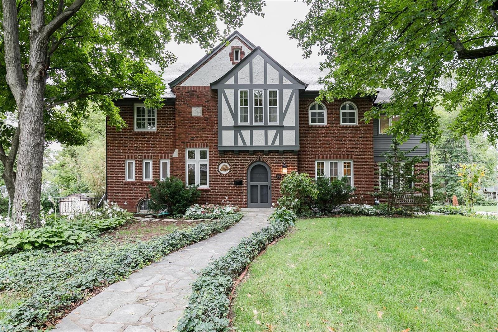 Beautiful, elegant Tudor home located on spacious level lot in much sought after Claverach Park. Large windows, skylights & refinished hardwoods create a bright, warm atmosphere. Main floor features new, professionally designed eat-in kitchen w/ granite counter tops, 42" cabinets and pantry cabinets w/built-ins, sub-zero fridge & high end appliances. Large living room W/built ins & dining room w/walk-out to expansive newer patio overlooking the spacious back yard... perfect for entertaining. Second floor features FULL LAUNDRY ROOM, 5 bedrooms, 3 baths; master suite w/vaulted ceilings, built ins, custom windows, & separate reading area.  Third floor has large family room, w/ many windows also skylights w/built in shades and screens; a great place to hang out. Beautiful, desirable, historic neighborhood. Walk to award winning schools, marvelous restaurants, Washington Univ., Starbucks, close to Forest Park, Enjoy all of Clayton right at your fingertips!