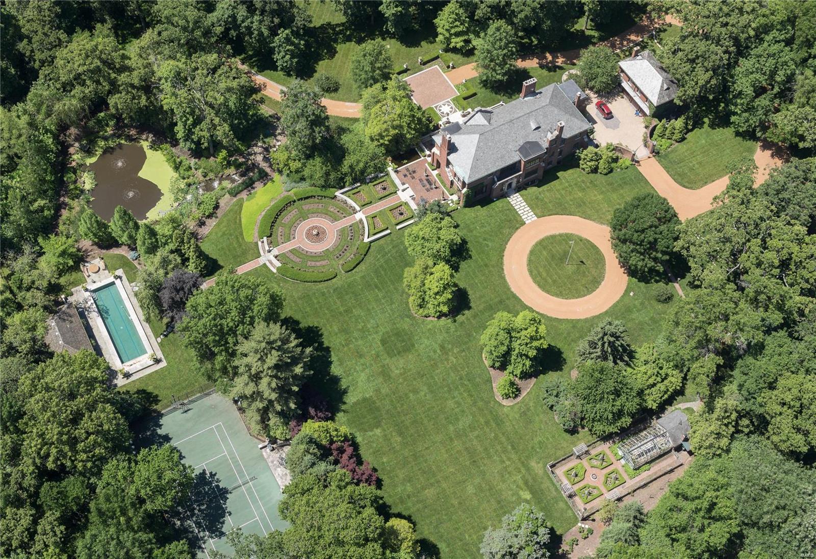 Resplendent and World Class. An 8 acre Ladue Estate where every need is met, every expectation surpassed. Hallmark features include gently rolling grounds, terraced gardens, a tiered waterfall and tranquil pond. The lap pool and pool house are exceptional; a lighted tennis/sport court and greenhouse, iconic. Formal rose gardens and organic vegetable gardens complete the setting. Rich history fills a main house of 10,000 SF in intrinsic architectural detail, transformed by the owner's accommodations to a modern lifestyle with an updated kitchen detailed in finest finishes. The primary suite is a lavish retreat with dual baths and dressing rooms. Smart Home features, a finished Lower Level, and comprehensive security are other key notes. A Carriage House provides ideal guest lodging. Reimagine intimate dinners, gracious receptions and extravagant fundraisers; a bespoke residence at a singular level that is nothing less than remarkable and breathtaking. Please hit Virtual Tour Link/video Additional Rooms: Wine Cellar