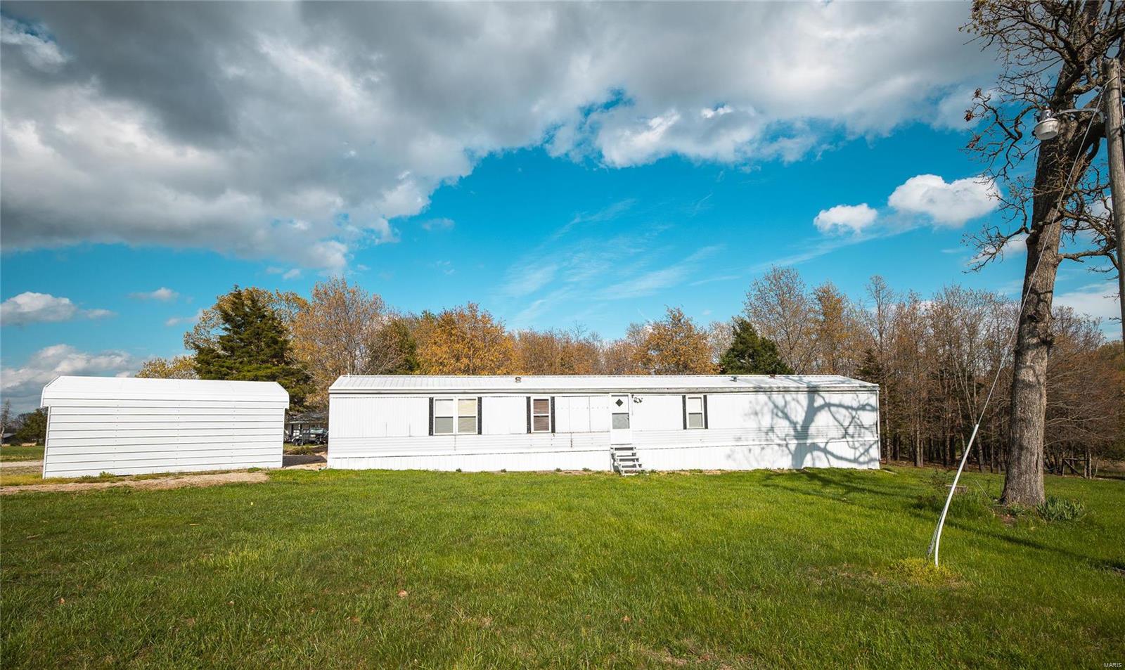 Escape to your private retreat with this well-maintained 3-bedroom, 2-bathroom single-wide home, nestled down a private road. This single-wide home has been lovingly upgraded, offering comfortable living in a serene setting. The home features a dining room, kitchen & living room, along with front & back entryways equipped with a washer & dryer for added convenience. Enjoy outdoor living on the spacious 16x20 covered deck, perfect for relaxing & entertaining. Equestrian enthusiasts will appreciate the 16x30 hay shed with an 8x8 tack room, along with the electric-fenced pasture centrally located, making it an ideal horse property. Additional amenities include a 2-car carport and a 12x16 shed with a lean-to, perfect for storing lawn mowers, 4-wheelers & more. The property offers ample privacy, with trees surrounding the back and east of the home. This charming and functional property is perfect for those seeking a peaceful lifestyle with plenty of space for horses and outdoor activities.