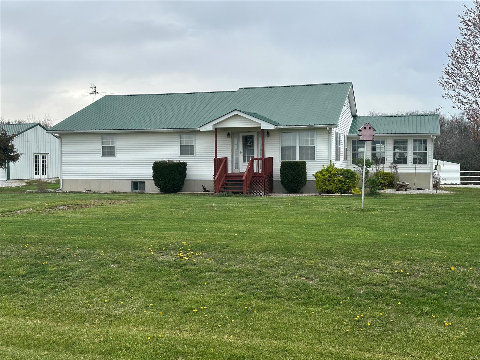 THIS INCLUDES BOTH HOUSES! Located just an hour and a half from St. Louis near the Mark Twain Lake sits this rare opportunity to own 59.29 acres of pristine land backing up to the Corp of Engineers and the Mark Twain Lake is visible as well. There is an abundance of wildlife and a 30 foot deep stocked lake with a 20x20 foot T-Deck. This is a set up for every Ranch owner's DREAM offering 7 outbuildings including a haybarn, Barn-100x100 with a middle drive through and several stables for boarding, a kitchen as well and, a 20x24 lean to and a patio off the back that leads to a party house you can use for entertaining, meetings, ect. The 120x220 arena with a covered grand and four gates. Also, updated manufactured home featuring new roof, siding, HVAC, windows and a beautiful newly remodeled master bath.  There are 5 metal round pins and crop ground to lease and unlimited things to use this property for. Additional Rooms: Sun Room