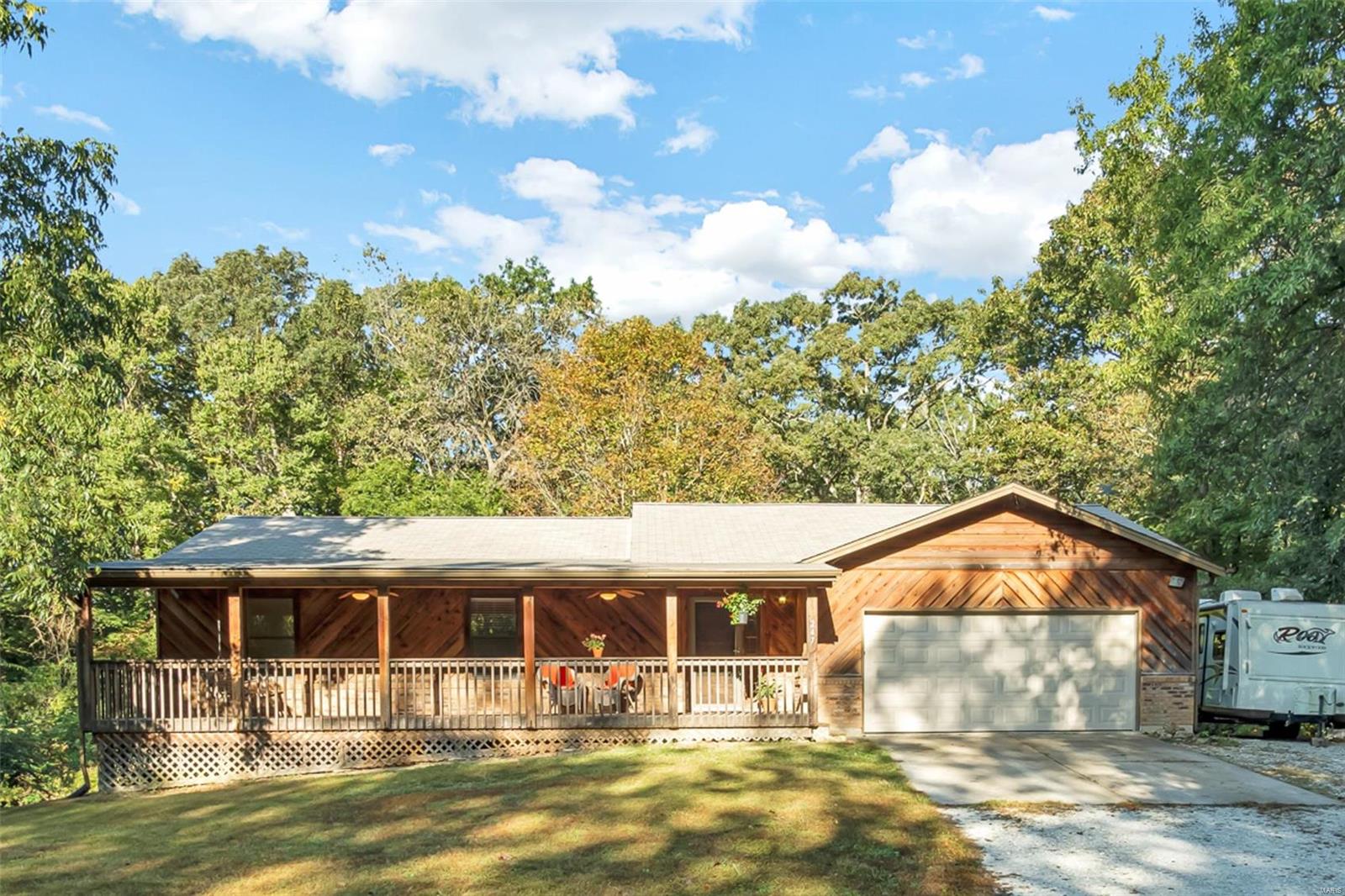 If you crave peace & serenity with a short drive to amenities, this lovely ranch on 4 wooded acres might be the one! Follow the gently winding private road to the very end, where you find this beauty nestled among the trees. Just 2.5 miles from Hwy 61 & 9 miles to I-70/64. A big covered front porch with lighting & fans provides a protected view of nature. Step inside to find a family room with a fireplace leading into the dining room & kitchen updated with undercabinet lighting, tile backsplash, double oven & a pantry. The slider opens to the deck with acres of trees to greet you. Private master suite with a walk-in closet & attached bath with a shower also enjoys those wooded views. Finished walk-out lower level has a living room, large & open rec room, powder room & a 2nd kitchen perfect for teens or in-laws. Oversized attached garage with tons of storage & a utility sink. NEW roof (2015), NEW water heater (2019), NEW septic aerator (2019). Wentzville Schools. See it today!