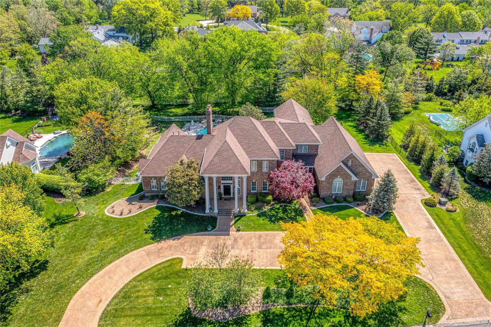 Spectacular John Porta-built Georgian Colonial in prestigious Highland Pointe. Impressive 2-sty foyer with dramatic floating staircase leads to private study with built-in bookcase & French doors, formal dining room & stunning great room with 2-sty bay window & granite fireplace flanked by lighted display cases. Designer kitchen featuring 42” white cabinetry, granite countertops, 12’ center island & convenient planning center adjoins light-filled breakfast room & vaulted family room with wet bar. Spacious master bedroom suite with His & Hers walk-in closets, sitting room & beautifully appointed bath with jetted tub provides an appealing retreat. Front & rear staircases access 3 additional ensuite bedrooms, bonus room & workout room. Lower Level entertainment space includes recreation room with fireplace & gathering bar, game room & media room plus sitting room, pool bath & 2nd laundry. Atrium doors open to outdoor living area with covered patio & pool surrounded by landscaped gardens.