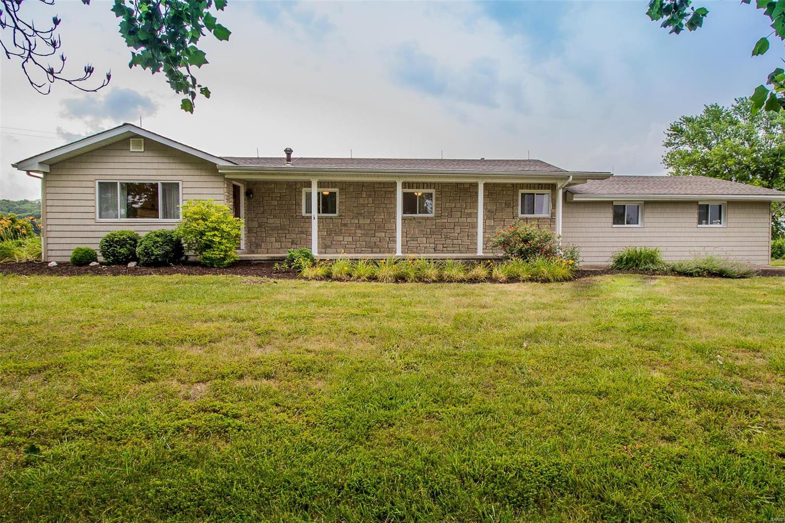 Outside of city limits yet within New Haven Schools! This 4-bed, 3-bath home has numerous updates! You'll instantly notice the newer siding, stone work & roof when you arrive. The covered front porch leads you inside, where you'll find updated maple flooring that flows throughout. The gas fp in the living rm is a beautiful focal point. The living rm is open to the kitchen & breakfast nook, which walks out onto the side patio. The kitchen features updated cabinets, quartz counters & stainless appliances. The kitchen island is a showstopper in a different finish. The owner's suite features a private bath & walk-in closet w/ custom organizers. Three addl bedrooms & a guest bath are also on the main floor. The walkout LL has a huge rec room w/ wet bar & laminate floors. The laundry, full bath (needs finishing), mud rm & storage are also on this level. The 2-car side entry garage allows for storage, along with the quonset bldg w/ concrete floor & elec, all on 6.71ac! Make it yours TODAY! Additional Rooms: Mud Room
