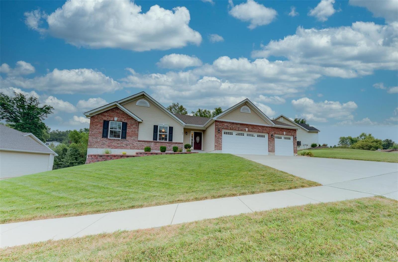 This one shows like a display! Immaculate brick & vinyl ranch home w/finished walkout L/L. Gorgeous vaulted great room w/wood flooring &attractive fireplace. Beautiful entry door & 2-panel arch-top interior doors. Baluster spindles on open stairwell. Spacious master suite. Stunning kitchen, staggered wood cabinetry w/crown moulding, center island, granite counter tops, designer back splash, double oven & stainless steel appliances. Large patio off breakfast room & a nice size backyard backing to trees. Lots of space in finished lower level, perfect for entertaining.  The coveted 3 car garage is insulated and drywalled, has epoxy finished floor & built-in cabinets for workshop area. A must see!