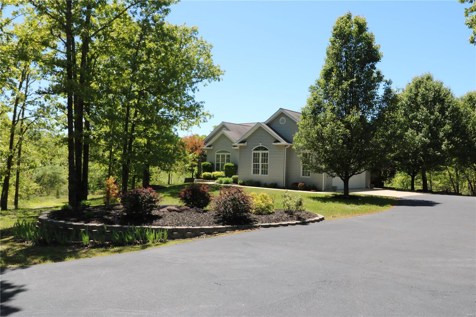 GORGEOUS & PRIVATE 5 BDRM/3 BATH HOME on 5 +/- ACRES just outside of town! From the moment you turn onto the asphalt driveway, you feel private and secure.  The driveway winds around to a very well-maintained 4000+ sq ft home nestled into a wooded landscape.  The main level of this Home offers a Vaulted Living Room w/french doors leading out to a composite deck for outdoor entertainment, a spacious Kitchen w/breakfast room & bay window to enjoy the private view, a separate Dining Room, Laundry/Mud Room, and 3 bedrooms (including Master Bedroom Suite) and an Office. The lower level features 9ft ceilings, a second Kitchen, a large Family Room w/french doors to a covered patio, two Bdrms w/walk-in closets, a Bathroom, and a Utility Room/Work Shop that ALSO has a double-door walk/ride-out! The home finishes include tall crown molding & baseboards, and wide doorways & hallways. The mostly wooded land has a wet-weather creek, scenic boulder formations, & lots more to explore! Additional Rooms: Mud Room