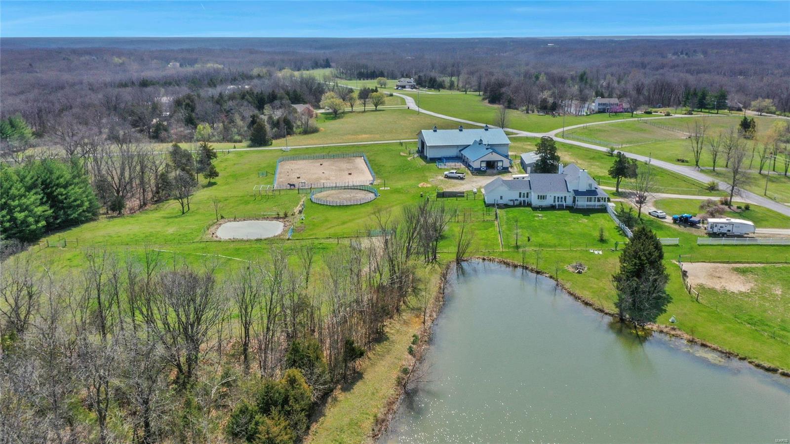 Showings stat Thursd. 3300+ sq ft Colonial 1.5 story home w/charming southern style wrap-around porch that leads you into the foyer, family room, main floor master bed, the kitchen and the large mud room. 2 fireplaces, large dining rm, updated kitchen w/quartz counters, dbl oven, breakfast bar, island, walk-in pantry. Yard is fenced for dogs w/individual runs. Paved roads & circle drive take you to this 27+/- acre Estate that includes 2 ponds a 3+/- acre lake, scattered woods & hay field outside of the subdivision. Morton barn has 6 stalls w/metal dutch doors that lead to paddocks, tack room w/laundry & bathroom, indoor arena, outdoor arena, hot/cold wash bay. 5 fenced pastures can be combined into 1 by opening gates, obstacle course, patience pole, large hay & equipment barn. You must see this one-of-a-kind property to believe. This set-up is missing nothing, with all aspects of caring for & training horses considered in the design and improvements. Dual zoned, generator & apple trees