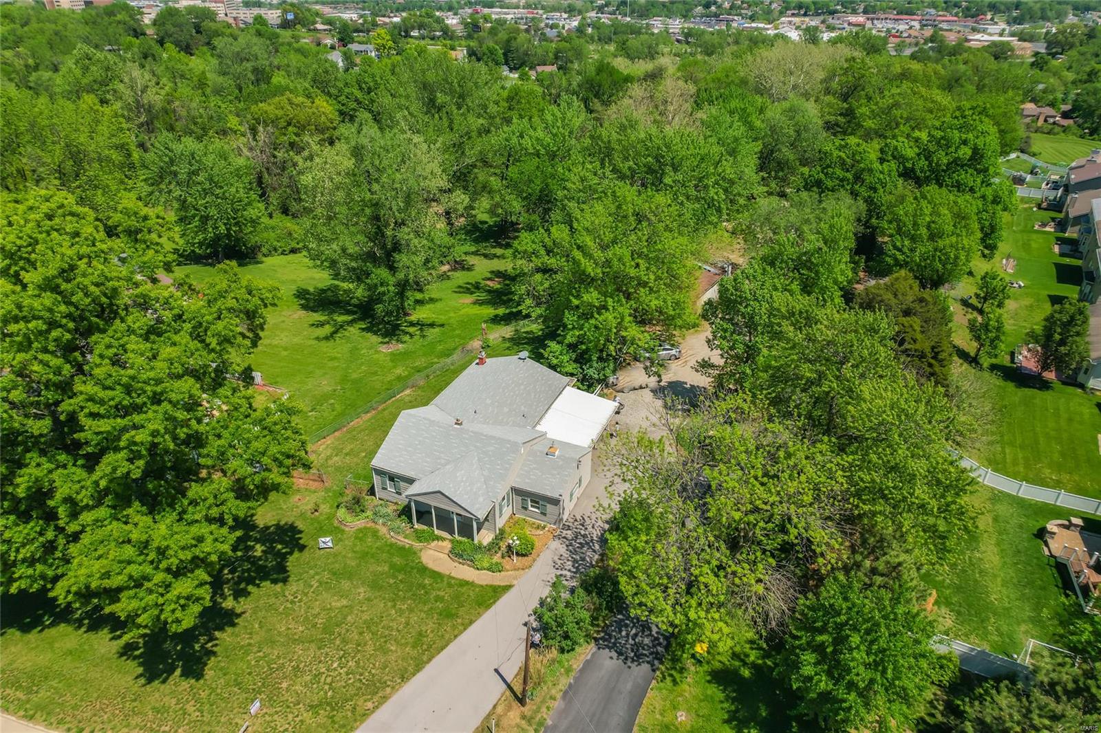 Unique Property in the Heart of Bridgeton!  2 Acre Level Lot, So Much Privacy!! 3 Bed, 2 Bath, Vintage Condition & Move in Ready - (Hall Bath Needs Updates) Original Hardwood! Huge Family Room With Fireplace & Opens to the Large Wrap Around Deck w/Seating! Enjoy the View and Wildlife - Deer, Turkey, Birds...  NEED STORAGE FOR THOSE 4 WHEELERS, MOTORCYCLES, BOATS, TRAILERS?? CHECK OUT THE HUGE - 30X25 STORAGE/WORKSHOP/SHED WITH A CONCRETE FLOOR! Additional Smaller Storage Shed for Those Smaller Projects! Rock Lined Fish Pond - YES - The Gold Fish Survived Another Winter! Add a Pump & Waterfall Flows!  Enjoy Various Flowers & Zoysia Grass! Property Has Been Owned By a Landscaping Company! Lots of Varieties! Property includes the road which leads to the home in back with a recorded easement. Sale Includes 12031 Old Saint Charles Rd (House) and 12029 Old Saint Charles Road (Road only)  SELLERS ARE MOTIVATED!
Home has been recently lived in and maintained. Property is being sold "AS IS".