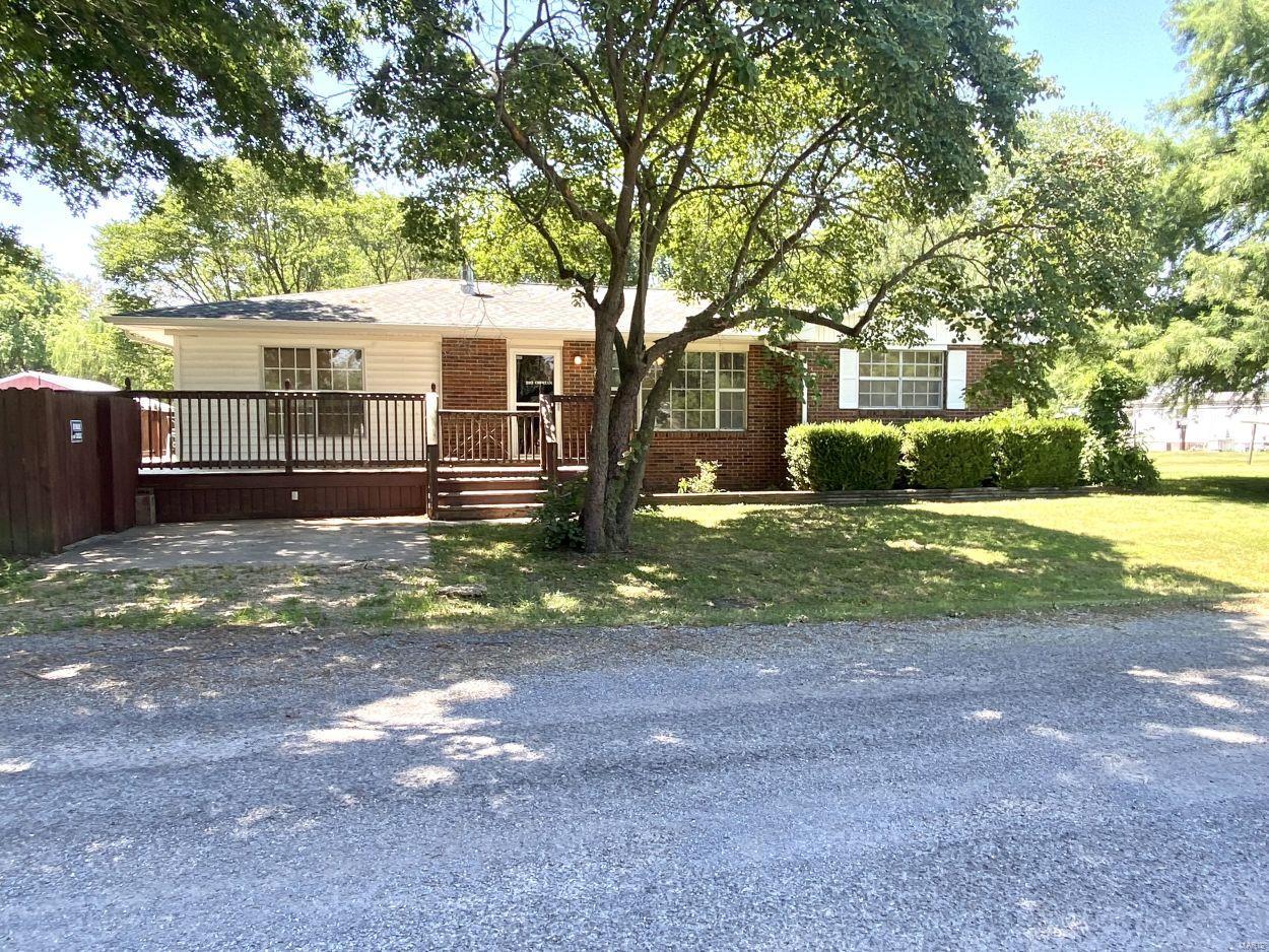 There are many perks to this property! The serene setting on almost one acre of land with plenty of mature trees is the perfect place to relax! The main house consists of 1696 square feet, and includes three bedrooms, one of which walks out to the wraparound deck, one and a half bathrooms, kitchen, living and two EXTRA spaces that would be great for office, additional family room, or a recreational room. Behind the house is a large two car garage or workshop with a 10 x 30 covered patio area. In addition to these is a 20 x 30 building with an overhead door, and a 10 x 12 storage shed. Youll never have to worry about bad weather, as this has a 6-person storm shelter right out the back door! The 911 address is 45 Cheri Lane, but the house address is 202 Cheri Lane.