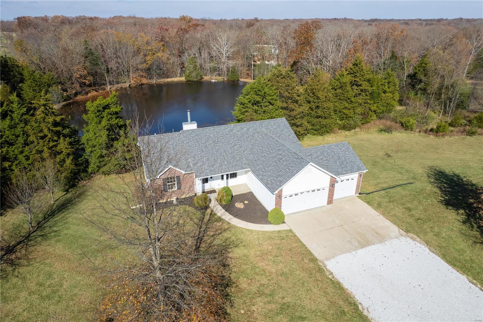 HUGE 5+ acre lot with a large private lake in your back yard!! The setting is a dream with scenic views everywhere! This is an absolute must see!! This home is beautiful and offers multiple upgrades throughout! Soaring vaulted ceilings greet you as you enter, with hardwood floors, wood burning fireplace, & lots of natural sunlight. Open floorplan boasts updated kitchen with brand new granite countertops, ceramic tile flooring, bar stool seating and access to the recently refinished deck overlooking the lake!! Divided floorplan features master suite with vaults and large master bath with separate tub and shower, ceramic flooring, and 2 separate closets! Two additional spacious bedrooms with updated hall bath! Large walkout basement has tons of potential to finish! Additional features include 3 car garage, freshly painted throughout, new dishwasher and kitchen faucet, fresh landscaping and clearing, tons of fields and space to play, and easy access to Wright City & Warrenton!