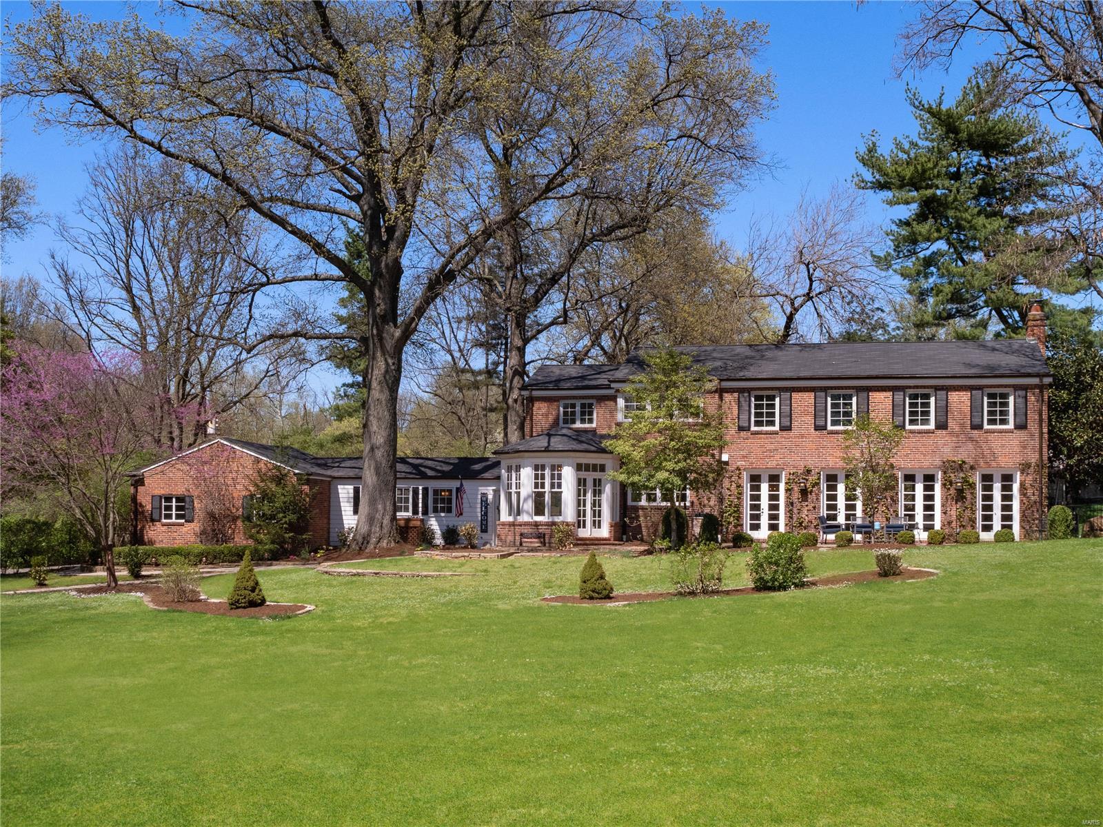 This elegant 4 bd, 4.5 bath home sits graciously on 1.5 acres tucked back on a private street in Ladue.  Light filled rooms accessing gorgeous patios set the tone and allow for both large indoor living spaces flowing seamlessly onto the outdoor living spaces.  This home features an updated kitchen with stainless and granite, a large breakfast rm and a mudrm/office with full bath and large family rm making up the informal family living spaces.   French doors from the formal living rm and dining rms lead to lovely brick terraces.  Dining rm is accented with MO Limestone floor.  All of this and a guest powder rm complete the first floor.  The fantastic second floor, perfect for a family, offers a master suite, with brand NEW luxury bath, custom walk in closet, another bedrm suite with private bath, 2 other bedrms, updated hall bath and updated laundry room!  This is a gorgeous setting offering a mix of a classic older home with modern touches for today’s busy lifestyle.