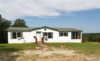 If your looking for privacy with a scenic view this is the home for you! Come sit on the deck of this 3 bedroom 2 bath home with a beautiful view of the valley while the cattle rome around the acreage below you. In the spacious living room you'll find vaulted ceilings and a wood burning fireplace. Next in the kitchen there is tons of cabinets and counter space, and the laundry room is with in the kitchen. You'll also enjoy the large dining room for the holidays. The master bedroom is separate from the other bedrooms with a large bathroom.  Property is fenced and crossed fenced its set up perfect for cattle with gates that open to extend both ways to exchange cattle from one area to another. Creek runs through property on lower level for watering the animals. There are plenty of trails for 4 wheeling and tons of deer and turkey around the property. There is a specialty cash crop on this property.   #16070238 adjoins this property and is for sale also. Buy both and own the hillside.