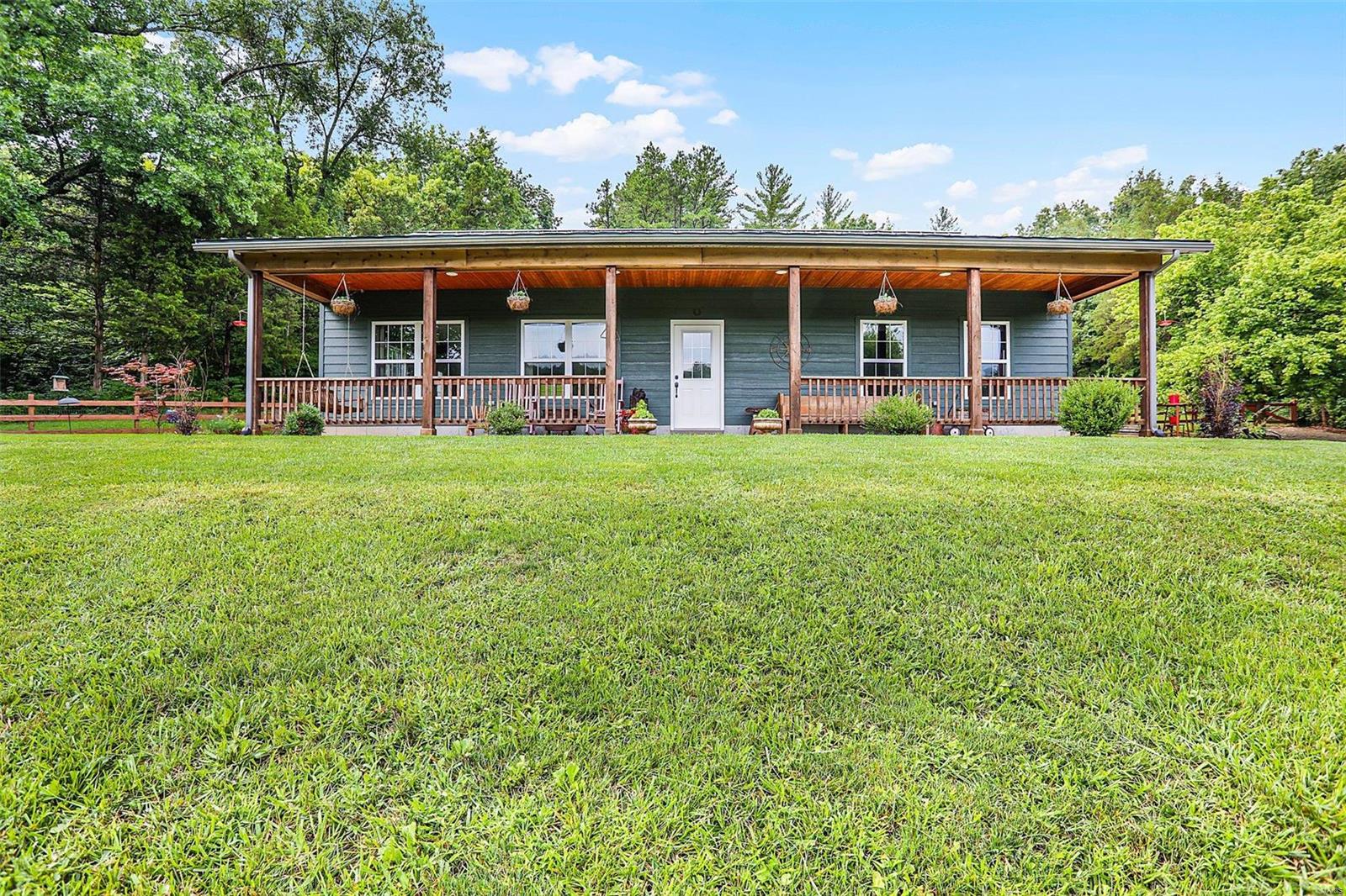 Charming 1.5-story home is nestled on 13+/- Acres in a peaceful & park-like setting surrounded by woods. Whether you're looking for a serene retreat or the perfect place to entertain this home could be it. Inviting farmhouse-style covered front porch welcomes you to step inside could be your dream home, the concept design intends to create a nice flow throughout. This home features on the main floor a living room, kitchen/dining combo, delightful kitchen w/breakfast bar, pantry & quartz countertops. Sizeable laundry room w/cabinets for added convenience & utility sink. Primary Suite w/walk-in closet, full bath with shower & dual sinks, full bath & 2nd bedroom. The upper level offers two additional carpeted bedrooms. 2 car detached garage w/extra living quarters could serve as a guest space or workshop. Covered back patio, large patio & round firepit area. Chicken coop for hobby farming. Raised beds for vegetable gardening. Creek offers a picturesque view. 2 parcel ID #'s. Must See!