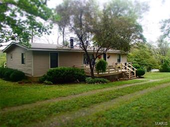 Zoned CD - residential and/or commercial use allowed! Perfectly located to run privately owned business while residing at the same location with easy access (aprox. 1 mile) to Hwy 100 and Interstate 44. Acreage is triangular in shape with trees and underbrush providing natural buffer and privacy to the road. Includes 24x36 detached 2 car framed garage. Property lies mostly level and largest percentage is in grass and could accommodate a horse or two. Residence is double wide mobile home manufactured in 1982 (per tax record) and is in good condition with 23x10 deck at front of home. Paddle fans in most every room with two full baths. 200 amp all electric service and wood burning fireplace in family room.