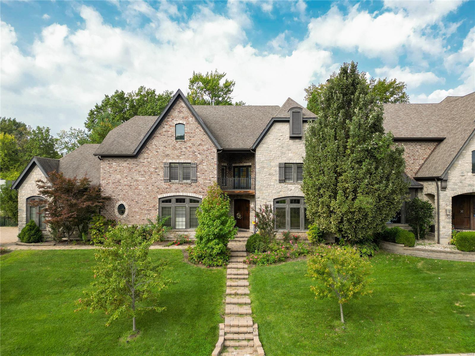 Exquisite details throughout this executive-style attached luxury home on a private lane in the Ladue school district. Brick & stone elevation. Custom stone pavers. Stunning solid wood arched front doors with visitor hatch open to a two-story entry foyer. Abundance of living space with 4 bedrooms and a finished LL. Works well as a multi-generational home. Warm wood adorns the office/den featuring a cozy fireplace and slate floor. Two-story great room with soaring stone fireplace. Cooks delight in the chef’s kitchen, built-in appliances, serving & central island & walk-in pantry. Beautiful main-level primary suite with remarkable custom closet system, AM/PM bar & a spa-like bath. Upper level offers an observation/cigar balcony plus 2 bedrooms with en-suite baths & large walk-in closets. Walk out lower level with 4th bedroom and full bath, a huge recreation space, and two storage rooms. Commercial-grade elevator services all 3 floors. 3 car oversized drywalled garage with service door. Some Accessible Features