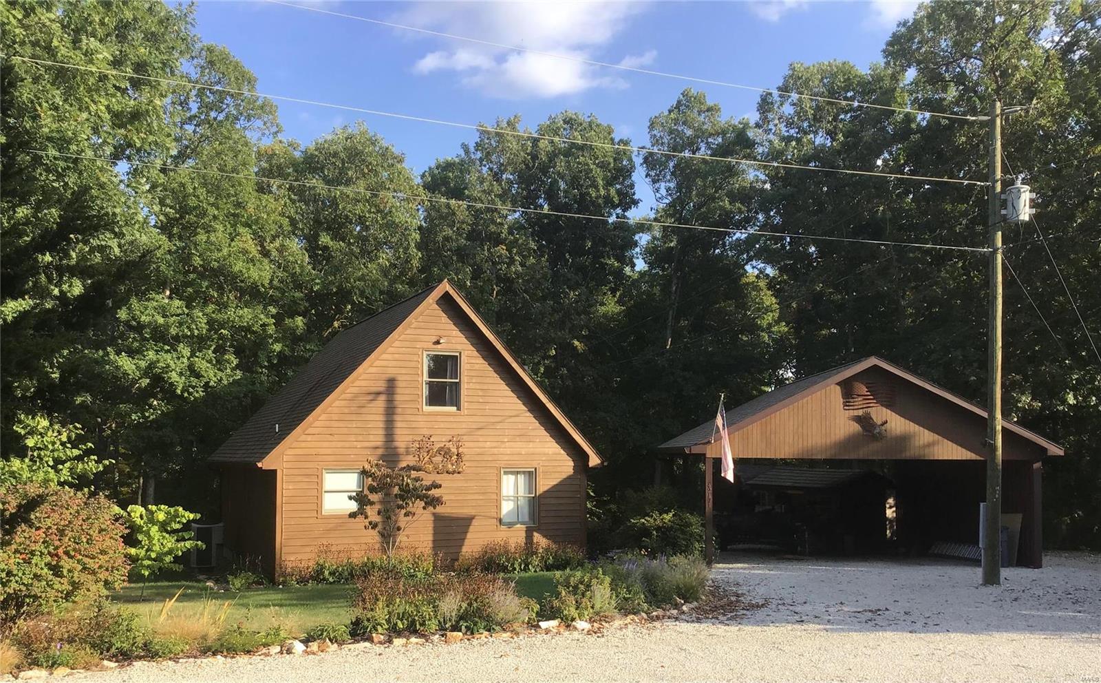 Whether you are looking for a weekend getaway, full-time home, or investment to rent out you don't want to miss out on this beautiful 3 bed/1 bath cabin located just minutes from Mark Twain Lake, Perry & Monroe City. As you walk in you can't help but feel the coziness of the tongue & groove pine while noticing the openness of the living/dining combo that flows into the kitchen. You will find 2 large bedrooms & landing area in the upper level as well as a main level bedroom, full bath & laundry hook-up. The beauty doesn't stop within the walls of this home. Spend your peaceful evenings lounging on the deck or around the fire pit, either way, you will have an amazing view of your wooded back yard! The well kept landscaping in the front yard makes this adorable cabin something to enjoy from every angle. Covered parking protects your vehicle, boat, or jet ski & two sheds give you plenty of storage for gardening tools or lake toys. Located in a private subdivision, this cabin is a MUST SEE!