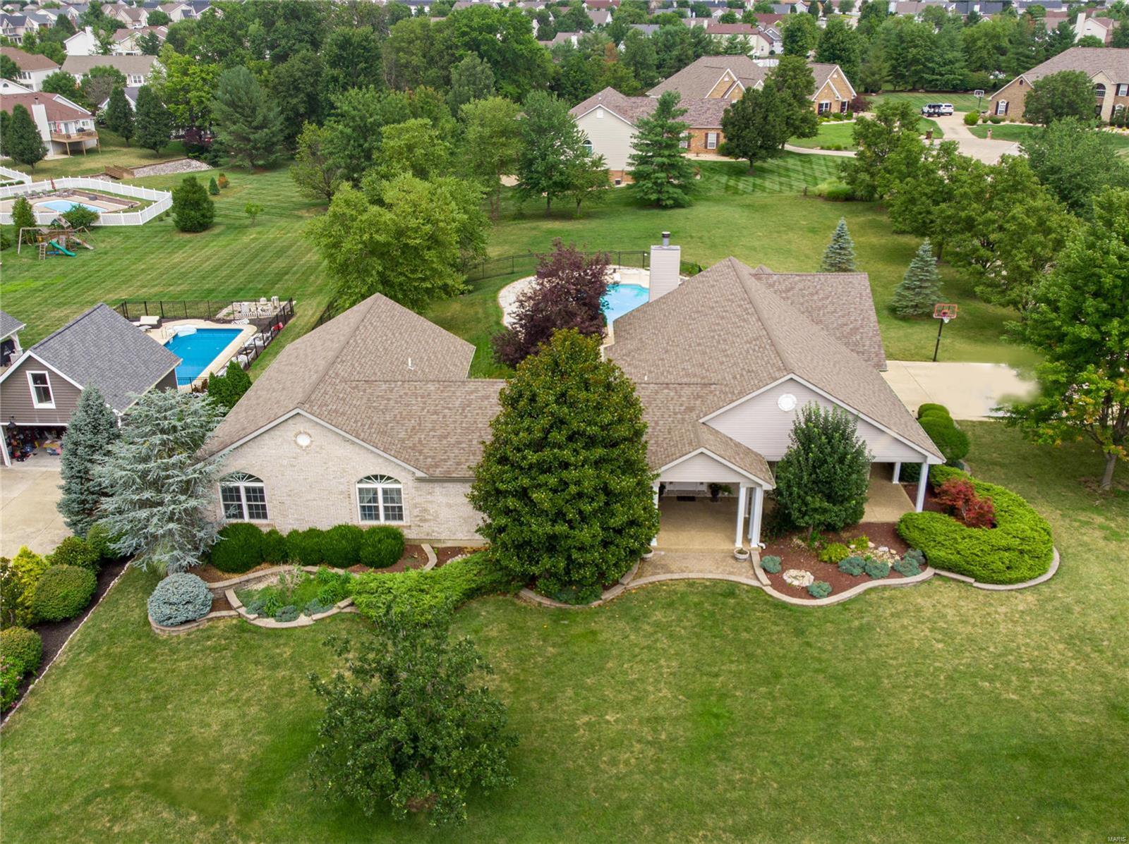 Custom sprawling ranch with LUXURY upgrades & SALTWATER POOL oasis, situated on ONE ACRE in the heart of Cottleville. Timeless curb appeal with predominant brick, expansive covered porch & professional landscaping. Bright entry foyer with wainscoting & arched doorways. VAULTED FAMILY ROOM wall of arched windows, sconces, fireplace & built-ins. Living room is open to formal dining (currently used as office) with lighted cove ceiling & butlers pantry. Large kitchen with generous wood underlit cabinets, crown, tile backsplash, center island bar, wine rack, WALK-IN PANTRY, stainless appliances & custom tile floor. Breakfast bay steps out to aggregate patio & iron-fenced pool & hot tub. VAULTED HEARTH ROOM with hardwood floors, fireplace & special millwork. VAULTED OWNER SUITE with bay window, WALK-IN CLOSET, built-ins, jetted corner tub, dual vanity & step-in shower. Downstairs is beautifully finished with rec/bonus rooms, guest suite, workshop & STORAGE. Convenient location near Hwy 364. Some Accessible Features Additional Rooms: Mud Room