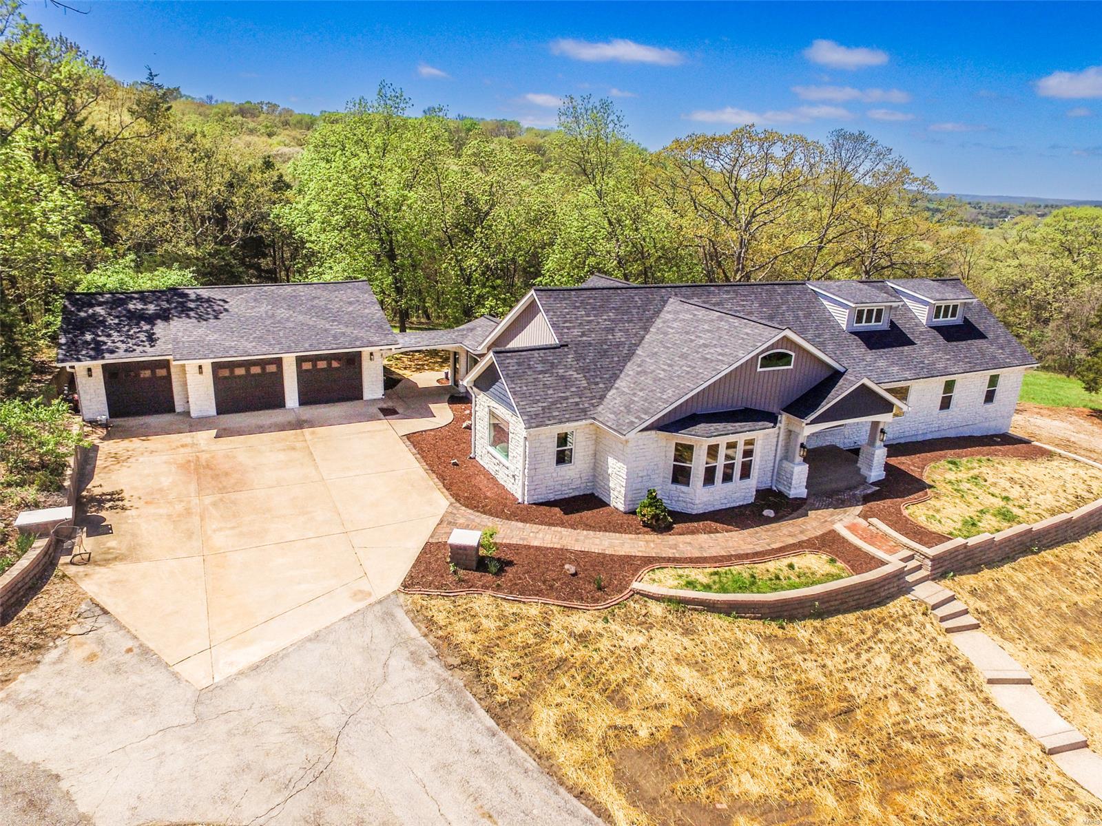 Welcome to your dream home! Stunning ranch-style residence nestled on nearly 5 acres of serene landscape. 
The main level of this beautiful home boasts an expansive layout with 4BR & 3BA, ensuring ample space for family & guests. The highlight, is the great room, showcasing a vaulted ceiling, recessed lighting, & built-in shelving, a perfect spot for entertaining. The spacious kitchen, is functional & stylish, it features an abundance of cabinets, a breakfast bar, Stainless steel appliances & elegant tile flooring.
The primary suite has a coffered ceiling, bay window & luxury bath featuring a soaking tub, walk in shower, his & her sinks, & vanity. The 2nd primary suite would be a great in-law quarters. Formal living & dining rooms offer elegant spaces for entertaining & the sunroom opens to a spacious covered patio, perfect for enjoying the outdoors year-round. The lower level has an additional BR, BA & a huge family room. There is a barn & pasture making it suitable for horses.