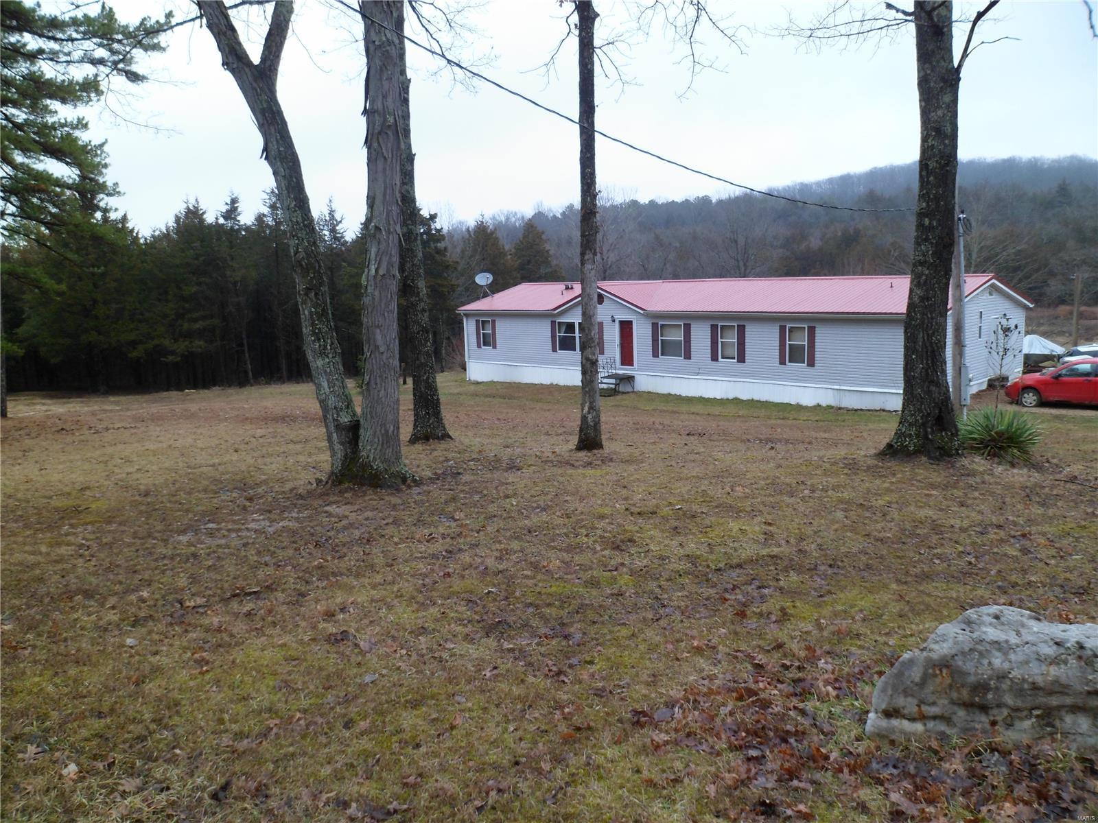 This home is situated on a very lovely setting of 11.83 acres. There are two parcels of land #08-10-11-00-000-0004.04 and          . 08-60-14-00-000-0002.11.  There are four bedrooms, master bedroom has his & her closets and great master bathroom which is partly remodeled.  There is also an office adjacent to the master bedroom for your special computer needs.  Beautiful built-in cabinet and woodburning fireplace adorn the family room.The huge living room also has a beautiful built-in cabinet & dining room is open space for family dining & entertaining. Large deck in rear of home along with a patio allow outside gatherings. New metal roof was put on in 2015.  Foundation is 3/4 slab and remainder is on piers. A small pond was being dug but needs some finishing. There is also a creek that runs across the back of property.  A storage building is located in the rear for tools, lawn mowers, etc.