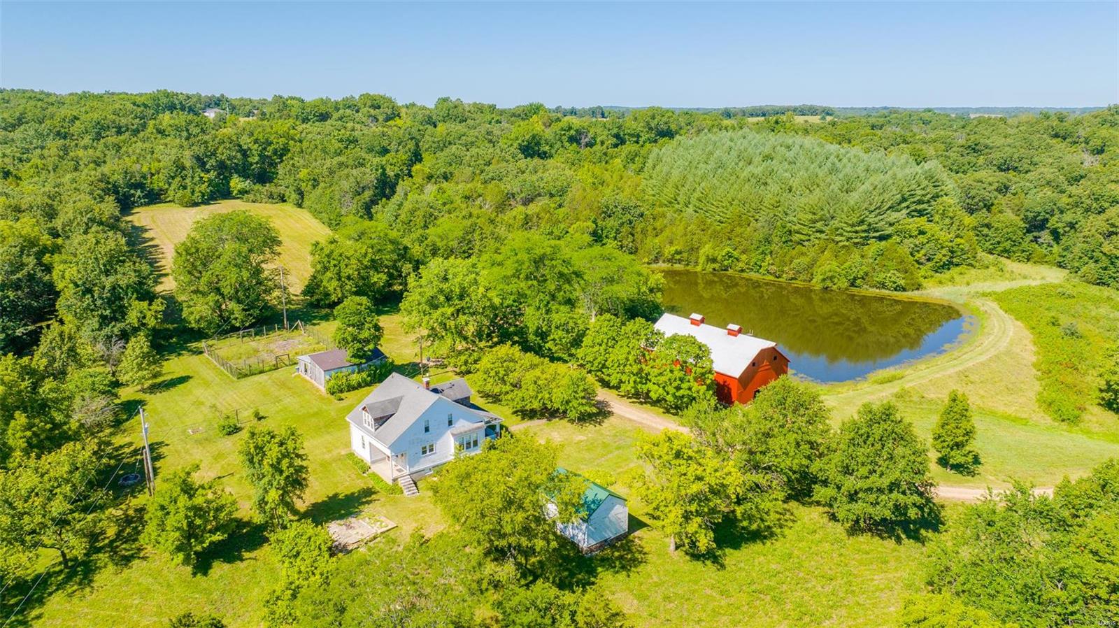 Charming 1929 bungalow, large red barn, and stocked lake!Rare Depression era home-built to last!Original redwood clap board siding, wood floors, doors and trim. Make sure to peek into the 4 attic coves!Farms of this character are indeed rare-110 acres-with a good mix of pasture, bottom ground, and mature woods. Private drive meanders past corn fields, over Whiskey Creek, past a scenic walnut tree grove, and then your first glimpse of farm life from days gone by!There is a 5-acre white pine grove that was planted by the current owner 40 years ago, that overlooks the 2-acre stocked pond-20' deep!Many well-established walking trails throughout the entire farm. You won't want to miss walking underneath the pine tree grove! Share crop income will be kept by current owners. Lease is verbal, so new owners could put in permanent pasture, and would make a fantastic cattle or horse ranch. New owners will enjoy complete seclusion and be proud to carry on ownership of this quaint country property!