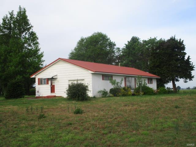 Check out this home, outside city limits and has 3.1 acres +/-. Three bedrooms, one bathroom, living room and kitchen with eat in area. Enclosed porch, metal roof and lap siding. County water and septic system. Kitchen has a double wall oven and stove top. Floor furnace and window air unit. One car garage attached, storage shed.