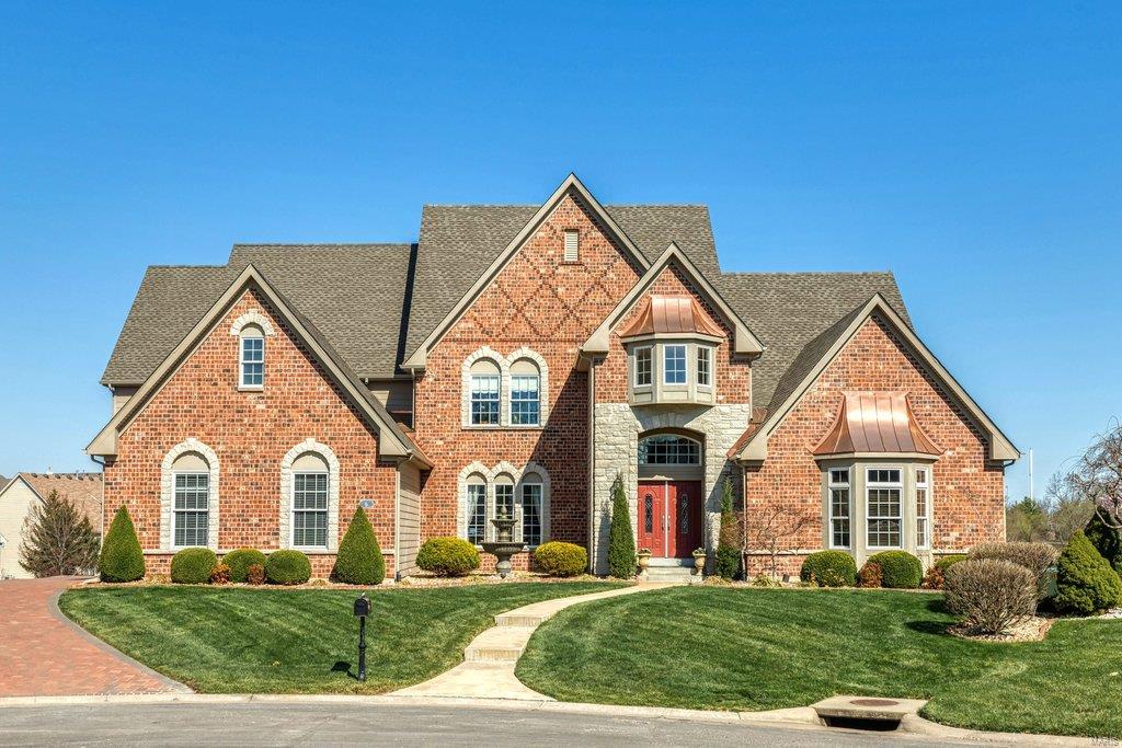 Spectacular lakefront Estate home in premier gated neighborhood. This brick & stone 1.5 Sty features extensive millwork, arched entryways & oak hardwoods that extend throughout the main living area. Impressive 2-sty foyer opens to private study, formal dining room & stunning great room with dramatic wall of windows & fireplace with full-height mantel. Designer kitchen with granite countertops, 42” maple cabinetry, KitchenAid appliances & butler’s pantry adjoins light-filled breakfast room & hearth room highlighted by floor-to-ceiling stone fireplace. Spacious master bedroom suite & luxury bath with jetted tub offer a relaxing retreat. Broad oak staircase accesses 3 additional bedrooms, 1 with ensuite bath & 2 with Jack n’ Jill bath. Walk-out Lower Level includes recreation room with 3rd fireplace, game room, coffered family room & media room with built-in entertainment center plus wine cellar, 5th bedroom & full bath. Situated on a .5-ac cul-de-sac lot with deck, patio & 3-car garage. Additional Rooms: Wine Cellar