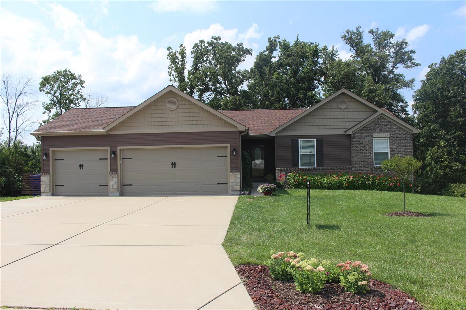 Welcome to your new home backing to trees. This home is in a great location, a couple minutes to stores in Warrenton and 15 minutes to Wentzville. Vaulted living room with shiny laminate wood flooring. You will love all the cabinets in the kitchen and the breakfast area with sliding door to the 10 x 15 deck. Master bedroom suite is vaulted with a plant shelf. The oversized 3 car garage is big enough to fit a suburban or oversized truck in. Current owner had the garage walls insulated, covered with OSB & painted, attic above garage blown-in insulation and had mini-split installed for heat/air. The walkout basement has a R/I for bath, has some framing up for walls, additional outlets and lights, new utility sink, a water softener and newer smart water heater. 10 x 12 shed with lofts in the back yard. Past seller added a buried conduit with pull string for future swimming pool pump. New leaf filter gutter guards and landscaping done in the last year.