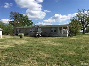 Fantastic Deal This Wont Last Long Bank says sell fast. Over 1540 sq ft double wide on concrete pads with concrete skirt on a corner lot in Richland Mo. This 3 bedroom 2 Bath Home has a full width covered deck a very open floor plan with a garage and another out building. Great lot very flat and clean in an excellent neighborhood. This is without a doubt the best buy for the money in the area. Whether you are a first time buyer or have a family or are retired you should really consider this home. Call today make arrangements to see this home today.