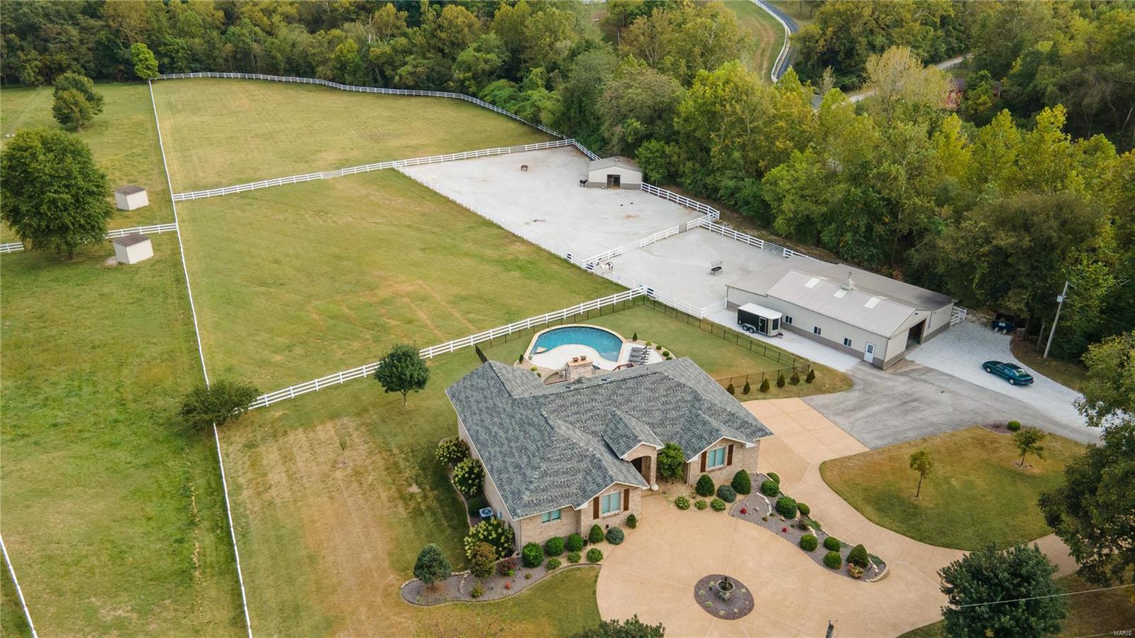 WOW LOOKING FOR THAT EQUESTRIAN PROPERTY THAT HAS IT ALL LOOK NO FURTHER! This beautifully updated walkout ranch overlooking a horse shoe shaped salt water pool with built-in wood burning fire pit and 5.7+/- acres of primarily all pasture. 2 Pastures, 2 dry lots, (2) outbuildings, 48x46 with (3)15x12 stalls and tack room. 20x30 Open span building. When you enter this beautiful ranch you walk into the open great room with a chef's dream updated kitchen white custom cabinets with double level large center island opening up into the breakfast room, dining room and covered deck all looking out onto the pastures and pool. The primary bath offers Quartz counters custom updated cabinets, separate shower and freestanding tub. The custom shelving in the primary closet are unbelievable. 4th Bedroom on main level has custom cabinets and built in desk. Lower level with fireplace, custom wet bar, Quartz counters ,5th bedroom and full bath. Must see!