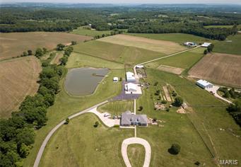 This gorgeous country estate is much more than just a property. Located off Hwy 61 just North of Eolia lies this custom built home with over 6,000 sf to live in & enjoy. Hang out in the big family room w/a fireplace, or retreat to the library. 6 beds w/plenty of room. Beautiful eat in kitchen w/a lrg island & granite counter tops. The lower level is home to a greenhouse w/direct access outside the basement door. LL also has living, kitchen, & dining area, big bedroom & bath, storage room, cedar closet, & playroom. 3Bd/2Ba Guest/Bunk, kitchen, dining, and family room, plus a 42x10 office at the back of the building. This beautiful home sits on 77ac & is currently registered as a 100% certified organic crops farm, fenced w/pasture sections for livestock, growing crops, or cutting your own hay. Plus a fully stocked lake to fish and enjoy. You could be self sufficient on this property. Machine shop & other out buildings.