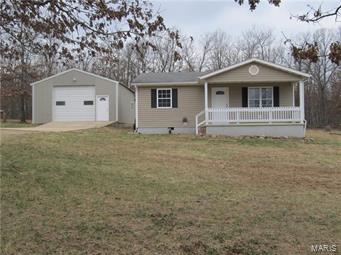 Adorable Country home set back from the road on 4.6 AC. Fenced and cross fenced for a couple horses-pond and building with a stall and place to store hay/feed. 2 Bedroom 1 Bath home can easily be expanded to add a master suite/living areas. All new Paint and Flooring 3/2016.  Inviting covered front porch with view of the stocked pond! Back deck for BBQ and relaxing. Inside has an open kitchen /living/dining area. Kitchen has white cabinets. Newer vinyl tilt out windows, central heat and air. There is also a 28x48 detached garage/shop that has a concrete floor  electric heaters and loft storage. 3 Door access, slider, remote , and walk-in. Wired for an air compressor .  Home sets adjacent to the National forest across the road and with in 5 miles of the Paddy Creek wilderness area/campground and nearby trail rides. Has a wood corral and a hitching post! Small hunting blind as well. All with in a short drive to the south gate of Fort Leonard Wood. Come make this your home in the country!