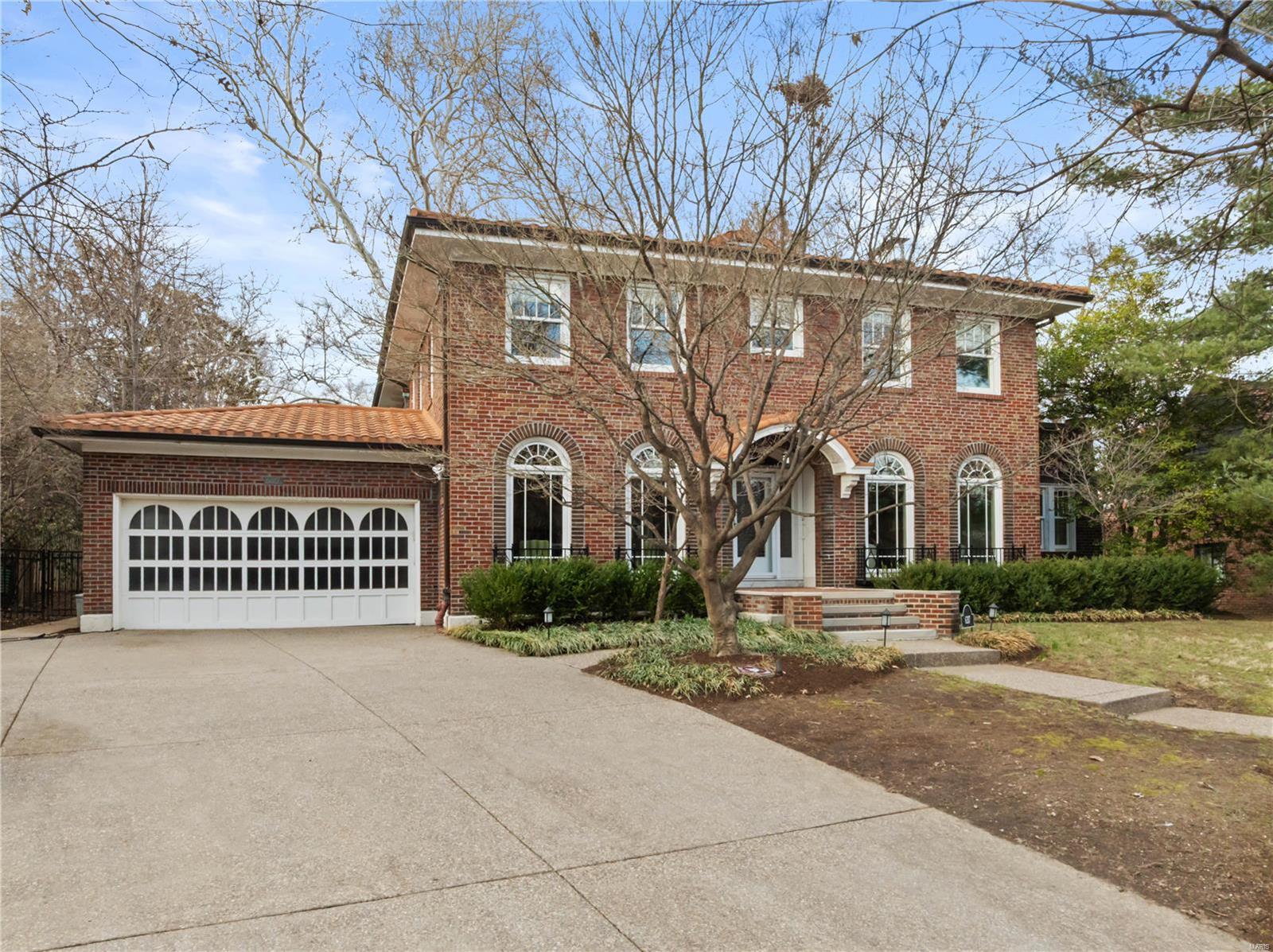 This exquisite 1920s Clayton home, set on nearly half an acre, offers timeless elegance with modern upgrades. Ideally located near top schools, hospitals, Wash U, and Forest Park. The home features new windows, ornate plaster moldings, and hardwood floors throughout. The foyer opens to a formal dining room with butler’s pantry/mud room access, and a living room leading to a charming sunroom. A well-designed two-story addition includes a spacious kitchen with Miele and Wolf appliances, a custom center island, and a family room with a gas fireplace and French doors to a travertine patio. The main floor has a full bath. Upstairs, the primary suite boasts an expansive closet, dual-vanity bath, and large shower. Three more bedrooms share two full baths. The fenced backyard includes a built-in Lynx grill, perfect for outdoor entertaining. A partially finished lower level with a full bath provides extra living space. Newer roof. Attached two-car garage. Additional Rooms: Mud Room, Sun Room