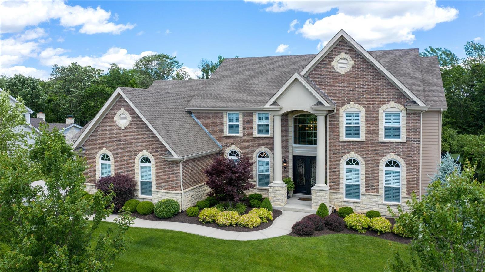 Why wait to build? Marvel at this magnificent better-than-new 1.5 story, 5200 sq ft home. Quiet enclave of executive homes. Impeccable attention to detail w/countless upgrades."Elegante" iron & glass front doors unveil a grand foyer, iron-spindle staircase, extensive millwork, 9ft ceilings/8ft doors, plantation shutters & job-finished wood floors. Expanded great rm w/gas fp & floor-to-ceiling windows showcase splendid views. Well-appointed kitchen leaves nothing to desire; center island w/double-stacked granite, gas cooktop, double convection ovens, built-in refrigerator, walk-in pantry & breakfast rm. Vaulted hearth rm w/gas fp leads to patio & large yard backing to wooded common ground. Relaxing main floor master suite w/spa-like bath; dual sinks, soaker tub, shower w/dual controls & heated tile flr. Upper bonus family rm w/surround sound. Fabulous amenities for living & entertaining: oversized 4-car garage, main floor laundry, multi-room audio system, landscape lighting & much more.