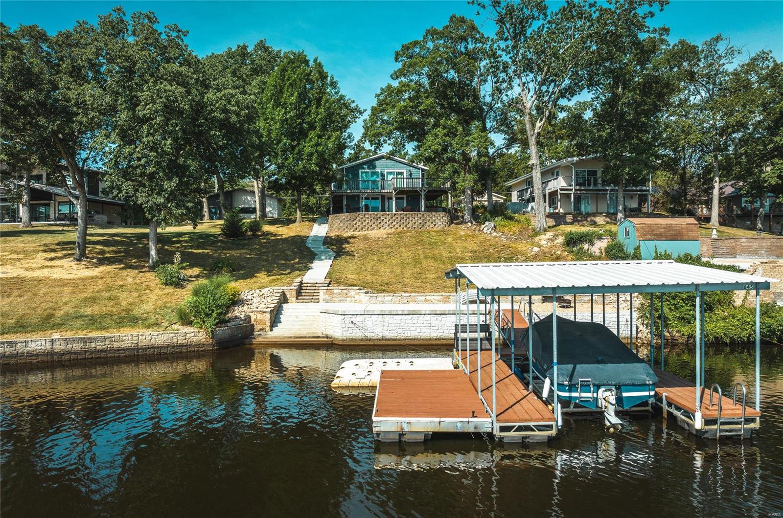 You can enjoy Lake Life THIS summer! This home is ready for you to move right in. Seller will leave most of the furniture. Featuring 3 bedrooms and 2 bathrooms on upper level and kitchen/living area and half bath on lower level, it is a perfect lake house set up. An easy walk to your private dock lets you get on the water quickly and easily. Covered dock and boat lift stay with the property. Relax by the lake and enjoy the sun rise with your morning coffee. The gated community features a 326 acre (+/-) lake for boating, fishing, swimming, tubing and skiing. Enjoy the use of a sandy beach area, tennis/pickleball courts as well as horseshoes. The community center hosts events and is available to rent for private functions. A full service marina assists with all of your boating needs. There is a new member fee equal to one year's dues. Please see www.ilpoa.org for additional information about the community. Jet ski docks do not stay.