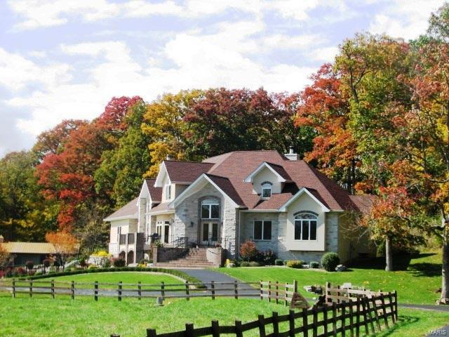 A picturesque 20+ acre setting overlooking scenic pastures and abundant wildlife just minutes away from shopping, dining and highway access. Outdoor amenities include a six stall horse barn, lighted riding arena, fenced pastures, in-ground heated swimming pool and waterfall. Luxury begins with the first step inside; rich hardwood, tile, soaring vaults, coffered and beamed ceilings, front and rear staircases, custom cabinetry, chef’s kitchen with high end appliances, balconies, two stone fireplaces,
leaded and etched glass. The home is ideal for entertaining with the kitchen, breakfast room, hearth and dining rooms all generously sized with breathtaking views. Master suite offers a private entry through the office, has coffered ceiling, box bay window and a luxury bath with dual vanities, garden tub w/columns, frameless glass shower and walk-in closet. LL has a
full wet bar, family room, enclosed rec room, full bath and walks out to the pool and outdoor serenity.