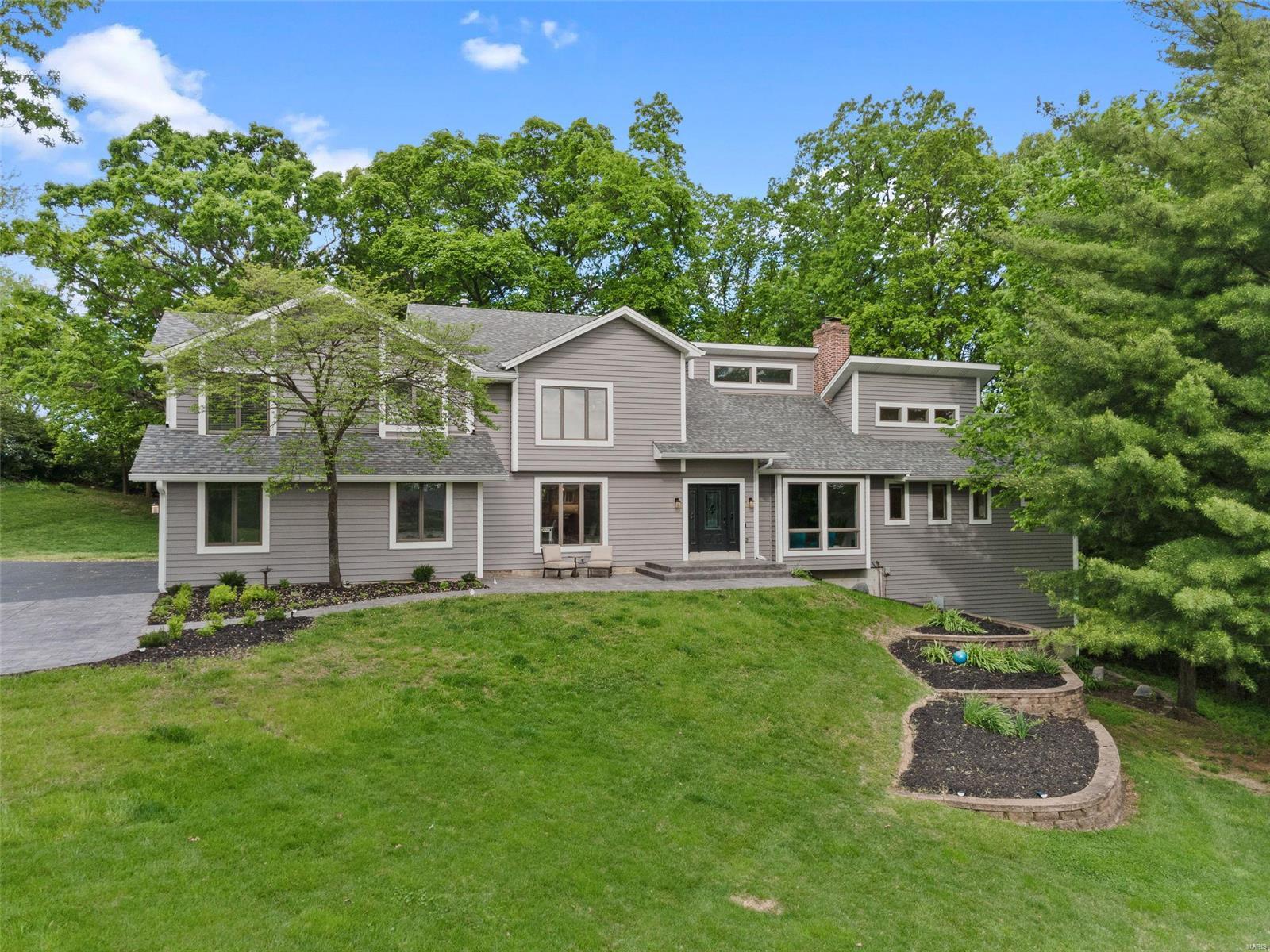 Nestled in Forest Hills this sleek updated home gives you the updates you want w/ privacy you desire. Soaring vaulted ceilings let in natural light throughout the home. Updated kitchen has 42 inch cabinets, quartz counter tops, dual ovens, induction cook-top, microwave drawer, built-in frig., wine frig., coffee bar, over sized center island, & is adjacent to the dining room.  Main floor master has vaulted ceilings, box bay window, & walk-in closet. Master bath boasts: steam shower, dual sinks, & jetted tub.  Upstairs 2nd master has updated bath w/ soaking tub, dual sinks, & walk-in shower. There are 3 additional bedrooms upstairs plus open loft. Walk-out LL has a rec. room w/ fireplace, wet bar, & door to the backyard fire pit. Huge LL bedroom has a box bay window facing the woods w/ full bath. Office/den is adjacent to the 1/2 bath & has a staircase leading to the oversized 3 car garage. Screened porch & Trex deck facing woods provides privacy. The home sides to the golf course. Some Accessible Features Additional Rooms: Mud Room, Sun Room