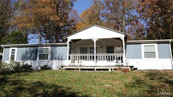 Enjoy peace and quiet while only being minutes from town w/ this adorable home nestled on 5+/- acres! As you enter through the updated, covered front porch, you'll immediately notice the new flooring & freshly painted walls all welcoming you into an open floor plan w/ a newer kitchen & living area. The master bedroom invites you in w/ its huge walk-in closet and bathroom offering a large, whirlpool tub and separate shower heated w/ an oversized water heater. Several windows w/in the home were completely replaced w/ a lifetime warranty! Not only does the inside of this home offer exceptional living area, but as you stroll outside to the gently wooded 5+/- acres surrounding you, you will find 2 ponds providing lots of lounging & fishing opportunities, and a 2 car garage offering tons of extra storage for all your families toys. You'll find this home is ready for all your needs w/ it's 2 sheds & a chicken coop! Sellers are very motivated & ready to welcome the next owners to their home!