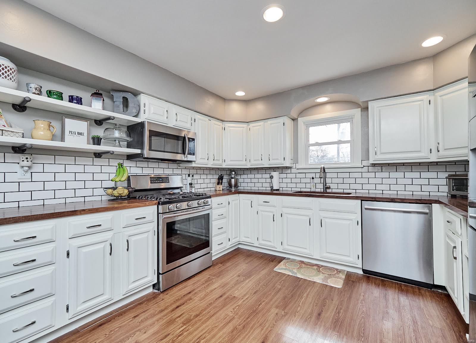 Welcome home to this 1947 brick bungalow in Historic St. Charles! Charming archways, coved plaster ceilings and original hardwood floors draw you in. Cozy wood burning fireplace completes the large living room. Full of updates! Updated main floor bathroom. Updated kitchen with SS appliances, subway tile backsplash, open shelving, gorgeous butcher block countertops and an original beautiful built-in hutch. Large, bright bedrooms. Half of the basement is finished and perfect for entertaining with bright lighting and a room that could serve as space for guests or an office. If there is one thing this house does not lack it is storage!! A total of 8 closets throughout the main floor and 3 storage rooms with built in shelves for extra storage in the basement. Large old built-in workbench for your tools and hobbies. Backyard includes a quaint brick patio, two car detached garage and a huge driveway with plenty of parking. Walking distance to Lindenwood University and Historic Main Street.