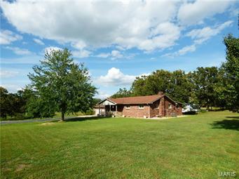 Beautiful well built home in Lebanon, MO.  This home sits on 20 acres, has a large pond and 2 large outbuildings, along with tons of yard to roam! Gorgeous quality wood work throughout home. From built ins in the spacious walk in closet, the beautiful hardwood flooring, sunroom hosts a wall of beautiful wood cabinets for storage... everything is gorgeous! Many, many updates! Complete remodel of master suite and extremely large bathroom also has a jacuzzi tub!. Beautiful open kitchen has lots of cabinets and countertops. All appliances stay with the home. Nice large sunroom with tons of light, to enjoy nature and the peaceful view also has entry to the back covered patio.  Full basement has large open area for rec room or den, bonus area and plenty of room to add another bedroom. Nice open land, home sits right on State Hwy 5 with long drive way to home, barn and shop. Shop has concrete floor & electric, large bay doors on front and side. All this and just inside city limits. Additional Rooms: Sun Room