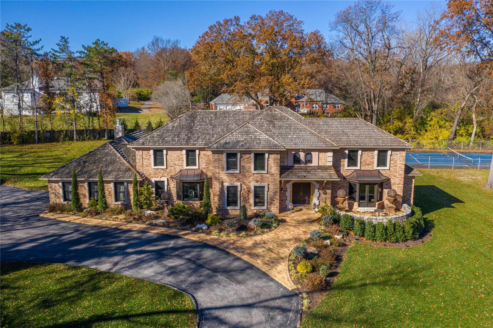 Located in one of Ladue’s most desirable neighborhoods, this extraordinary 1.5-sty Estate home features superior craftsmanship & meticulous attention to detail. 2-Sty marble foyer highlighted by dramatic floating staircase leads to private study that opens to terrace, elegant dining room & library-paneled great room with box beam ceiling, stone fireplace, built-in bookcases & spiral staircase. Chef’s kitchen with 42” cabinetry, granite countertops & 6’ center island adjoins breakfast room with wide bay window & vaulted sunroom with skylights & floor-to-ceiling stone fireplace. Master bedroom suite with cathedral ceiling & rustic beam trusses, His & Hers baths & sitting room provides an appealing retreat. The 2nd floor extends the living quarters with 4 additional bedrooms, 2 with ensuite baths, & hall full bath. Lower Level includes recreation room, game room, wine cellar & full bath with sauna. 3-Acre cul-de-sac lot with 2 patios, pool & tennis court surrounded by landscaped gardens. Additional Rooms: Wine Cellar