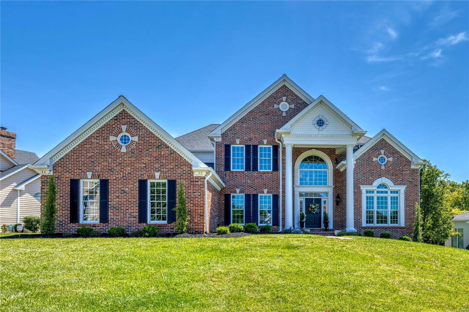 Stately full-brick Georgian Colonial in prestigious Manderleigh Estates. This Miceli-built 1.5 Sty features soaring ceilings, oak hardwoods, detailed millwork & palladian windows. Impressive 2-sty foyer highlighted by dramatic curved staircase leads to private study, formal dining room & stunning great room with architectural columns, walk-behind bar, fireplace with handcrafted mantel, built-in bookcase & 2-sty wall of windows. Designer kitchen with 42” white cabinetry, granite countertops, 5’ center island & butler’s pantry adjoins breakfast room with convenient planning center & French doors to patio & vaulted hearth room with floor-to-ceiling stone fireplace. Primary bedroom suite combines the enjoyment of a marble fireplace with beautifully appointed bath with jetted tub. T-staircase accesses 3 additional bedrooms, 1 with ensuite bath & 2 with Jack n’ Jill bath. Lower Level includes recreation room with wet bar & 4th fireplace, game room & media room plus workout room & full bath.
