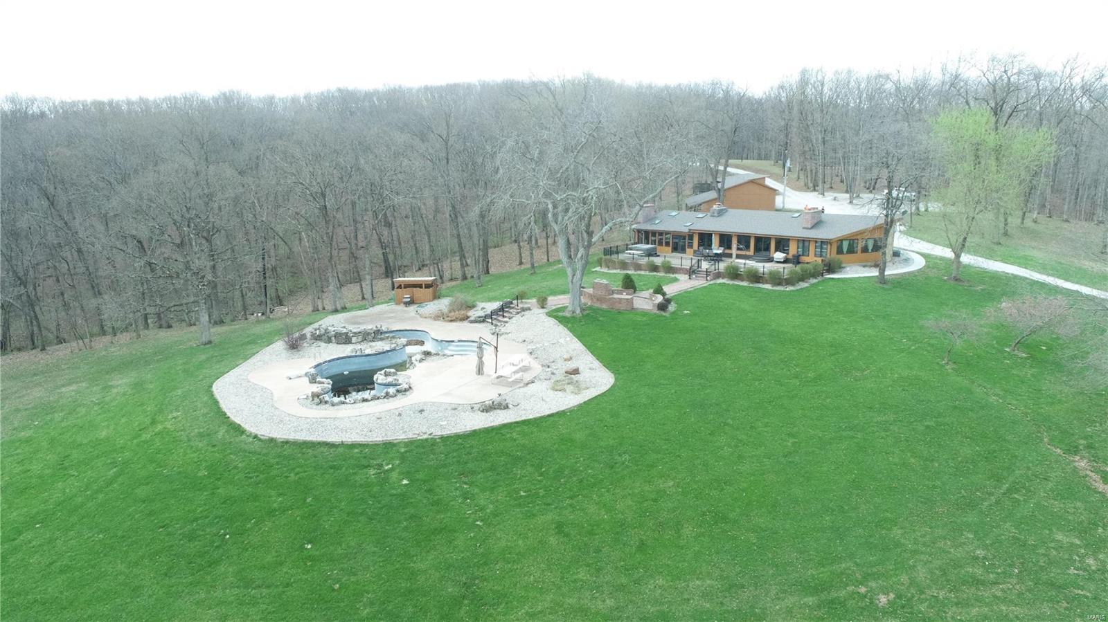Located in the scenic hills of northern Lincoln County lies this pristine 184 +/- acres.  Turning off of Blue Bird Hill Rd. onto your secluded private drive sits a beautiful 2,233 sq. ft. 3 bed, 3 bath rustic ranch home. The views off the spacious back porch include an in ground pool, custom brick bbq grill and a glacier cut valley of fertile soil edged by Sandy Creek.  Outside of the home is a barn with stables for horses, a circle paddock and equipment shed.  These amenities provide the perfect place to bring the horses to the farm and trail ride.  Below the home sits a small lake with plenty of fish to be caught.  Being located in one of the more sought after areas in Missouri for growing big whitetails and having a large turkey population provides the avid hunter abundance of opportunity on this farm.  The layout on the property is well balanced for hunting consisting of plenty of fields for food plots, trail systems, creeks, ridges and meadows. Truly a dream farm!